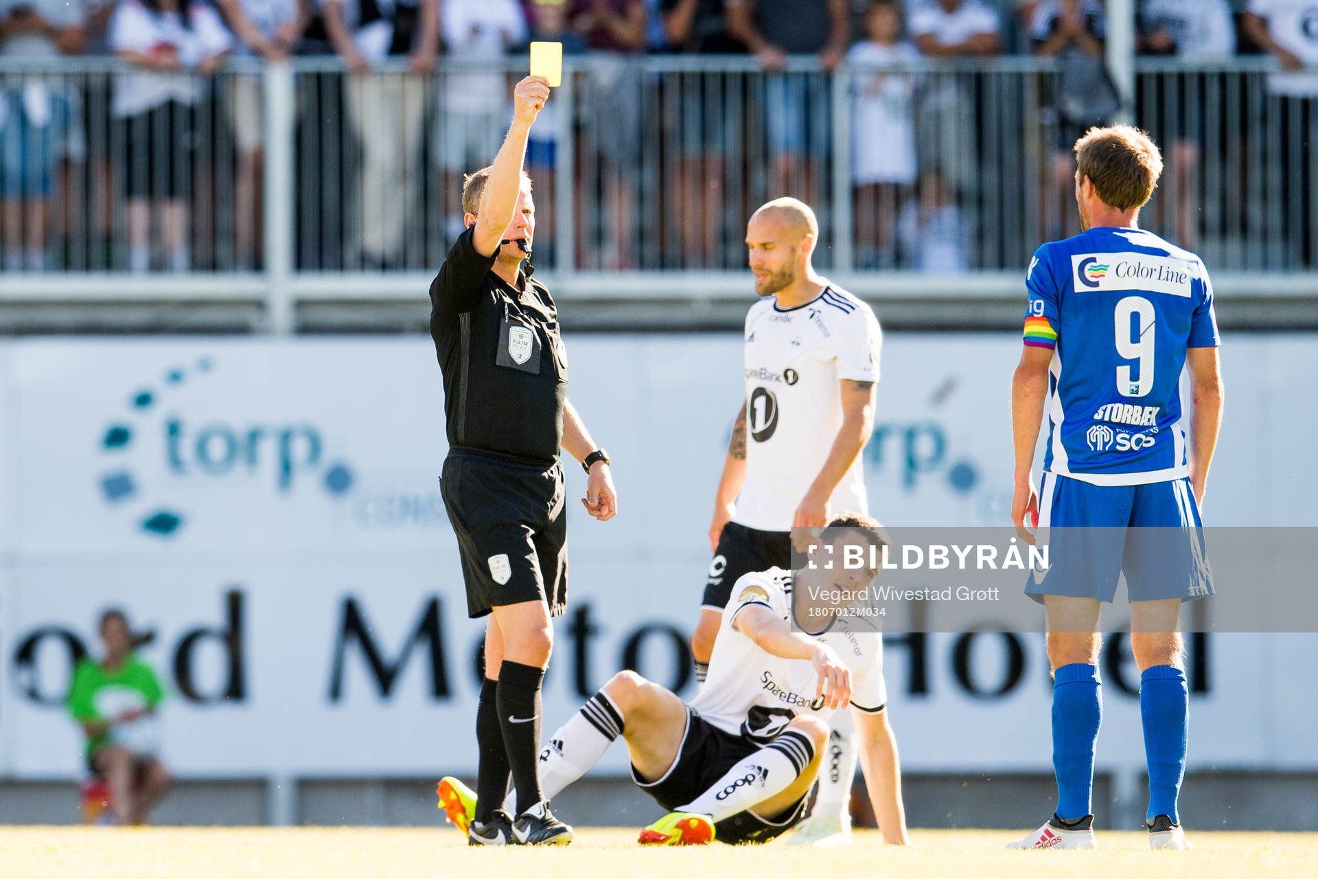 Håvard Storbæk of Sandefjord is shown a yellow card by Trygve Kjensli, referee, during the Eliteserien match between Sandefjord and Rosenborg on July 1, 2018 in Sandefjord.