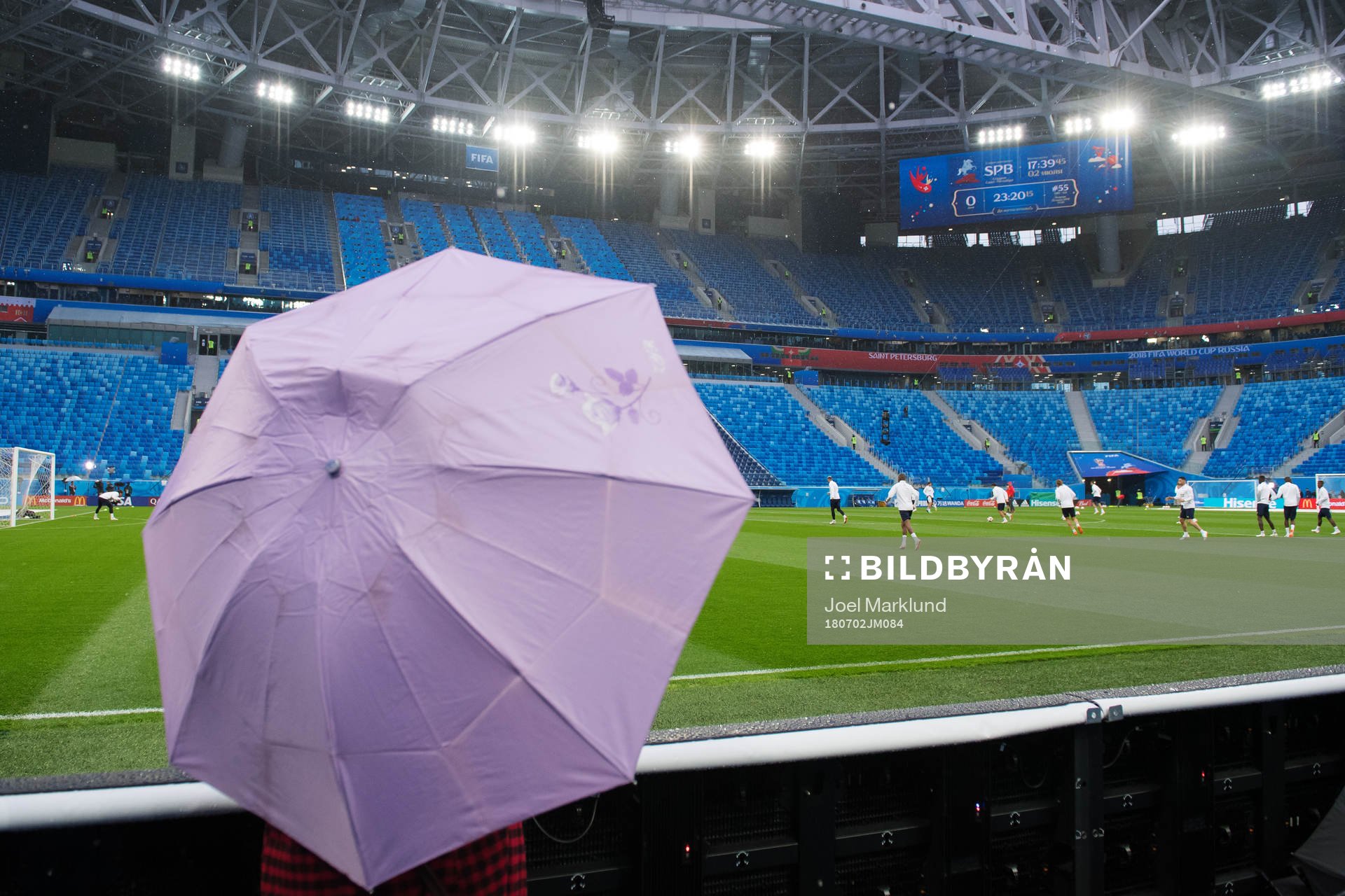 A member of the press holds an umbrella when watching the