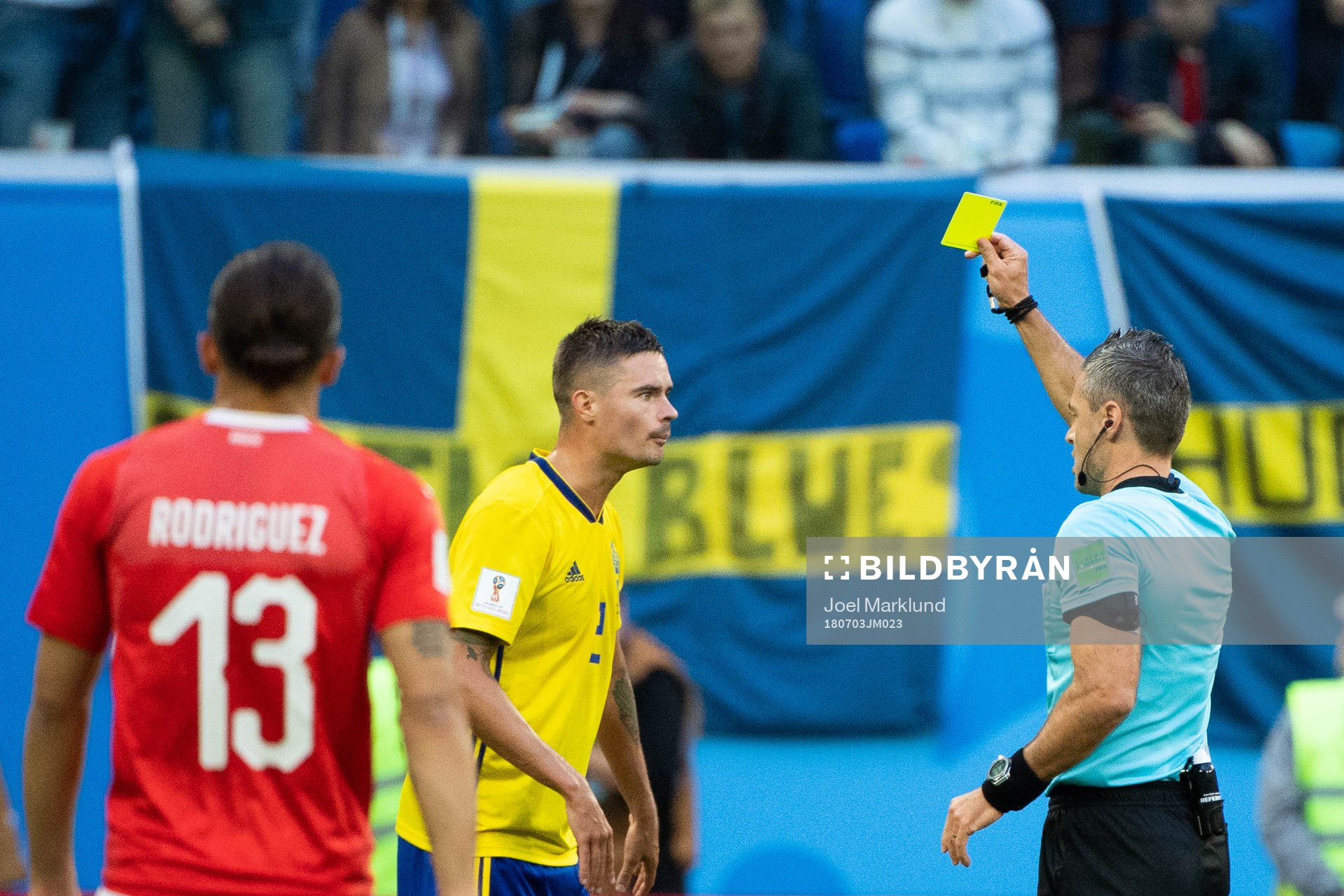 Mikael Lustig of Sweden is given a yellow card