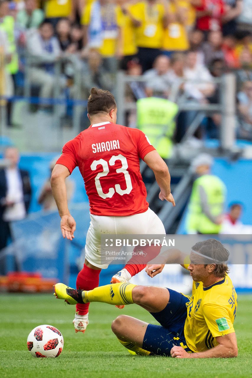 Gustav Svensson of Sweden tackles Xherdan Shaqiri of