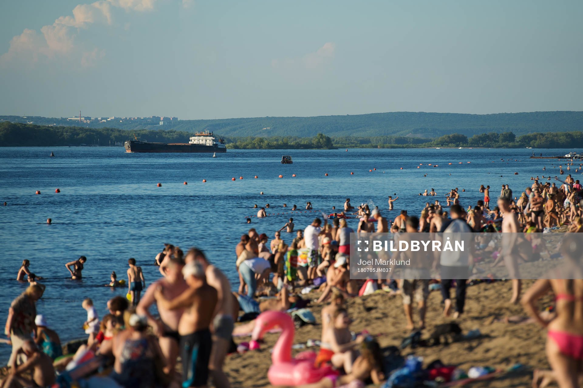 A boat passes by a beach