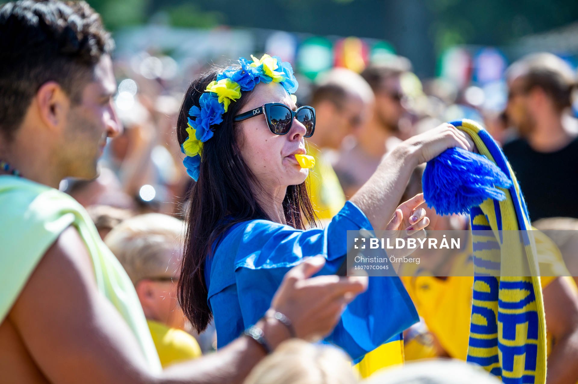 Kvinnlig supporter med visselpipa följer matchen mellan