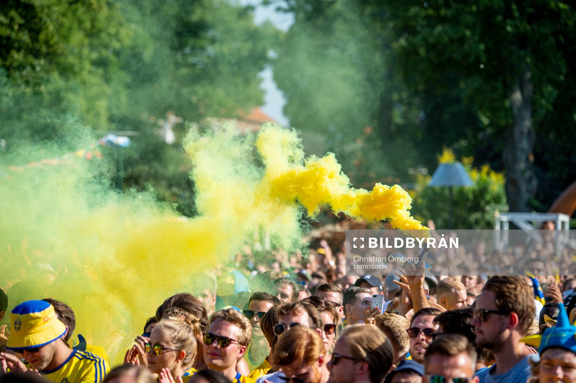 En supporter tänder en gul rökgranat innan matchen mellan