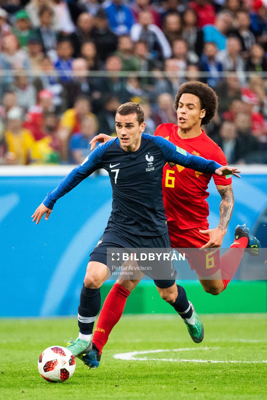 Antoine Griezmann of France competes for the ball with Axel