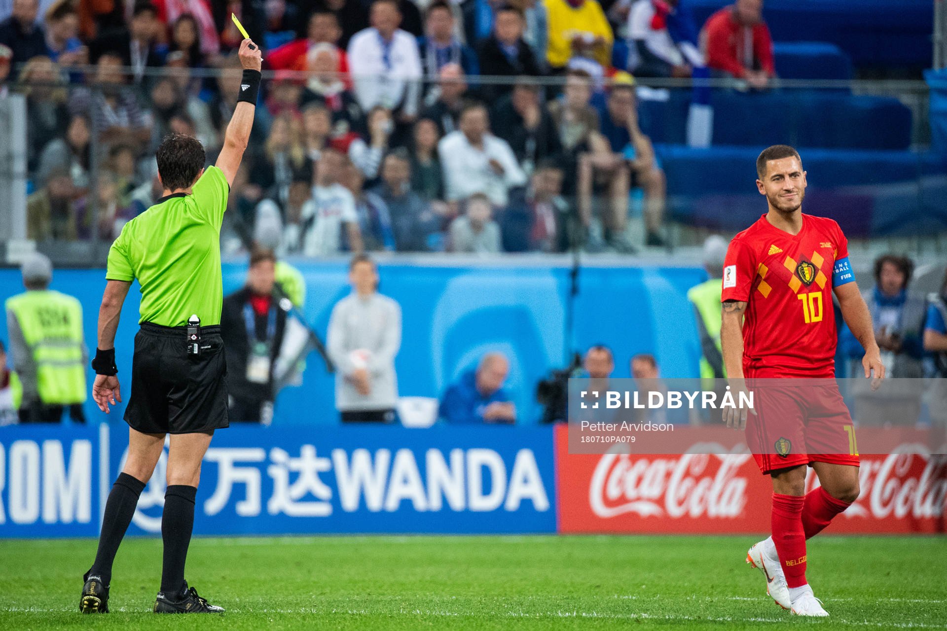 Eden Hazard of Belgium receives a yellow card bby referee