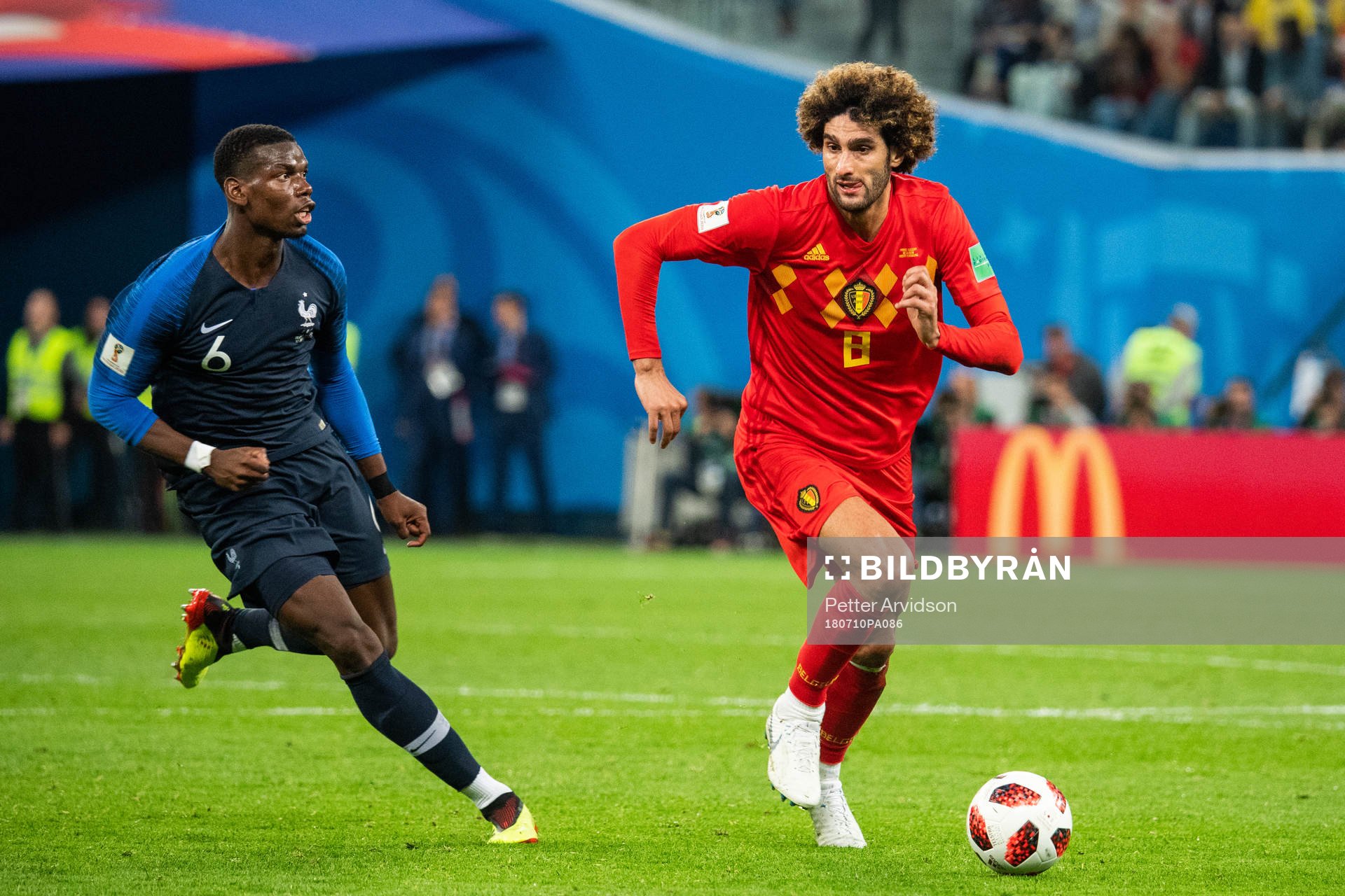 Paul Pogba of France chases Marouane Fellaini of Belgium