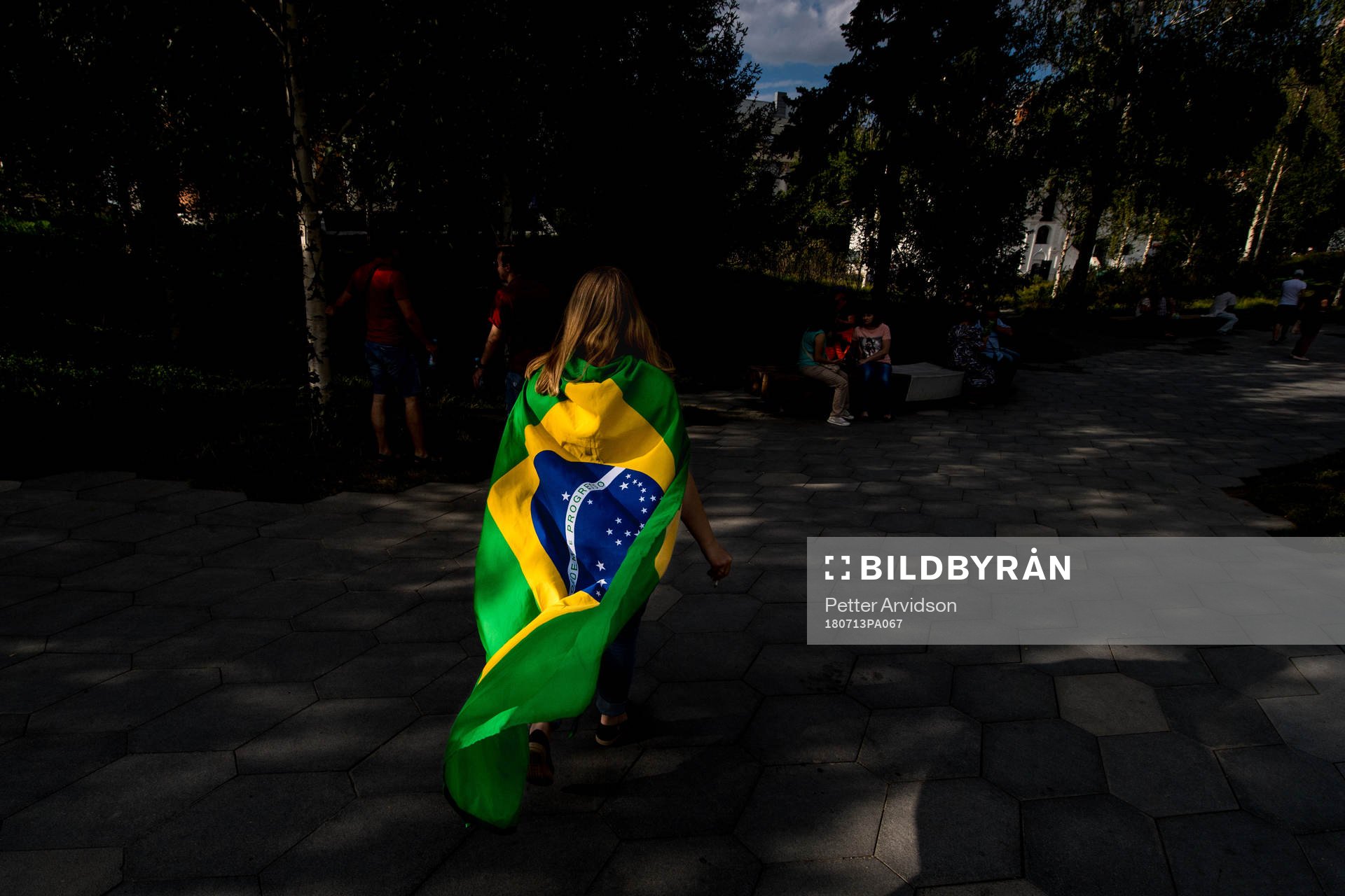 A fan of Brazil are seen walking in a park in central Moscow