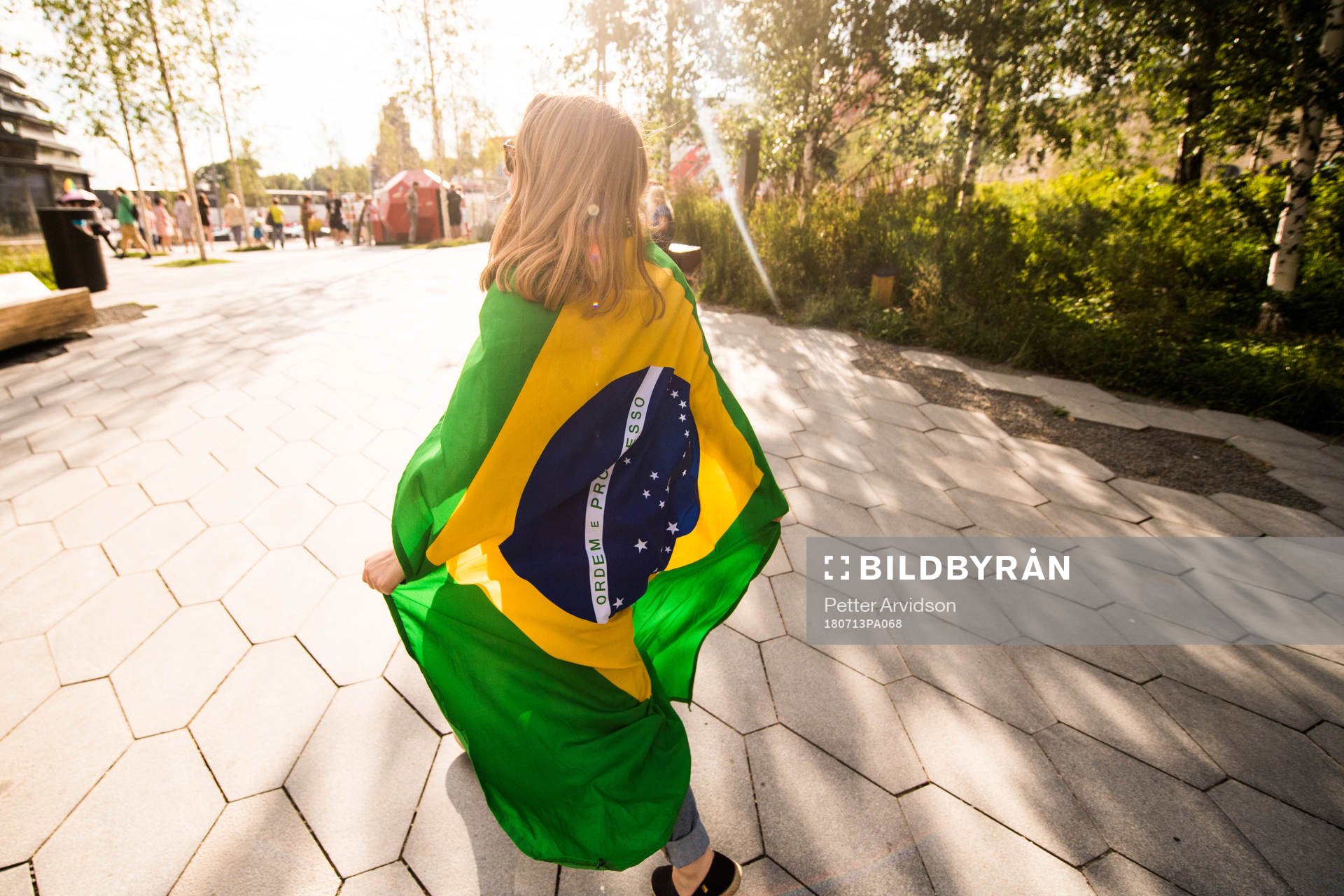 A fan of Brazil are seen walking in a park in central Moscow