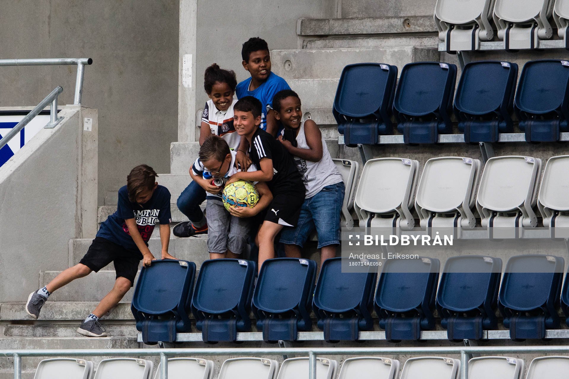 Unga åskådare tar hand om en matchboll som hamnat på