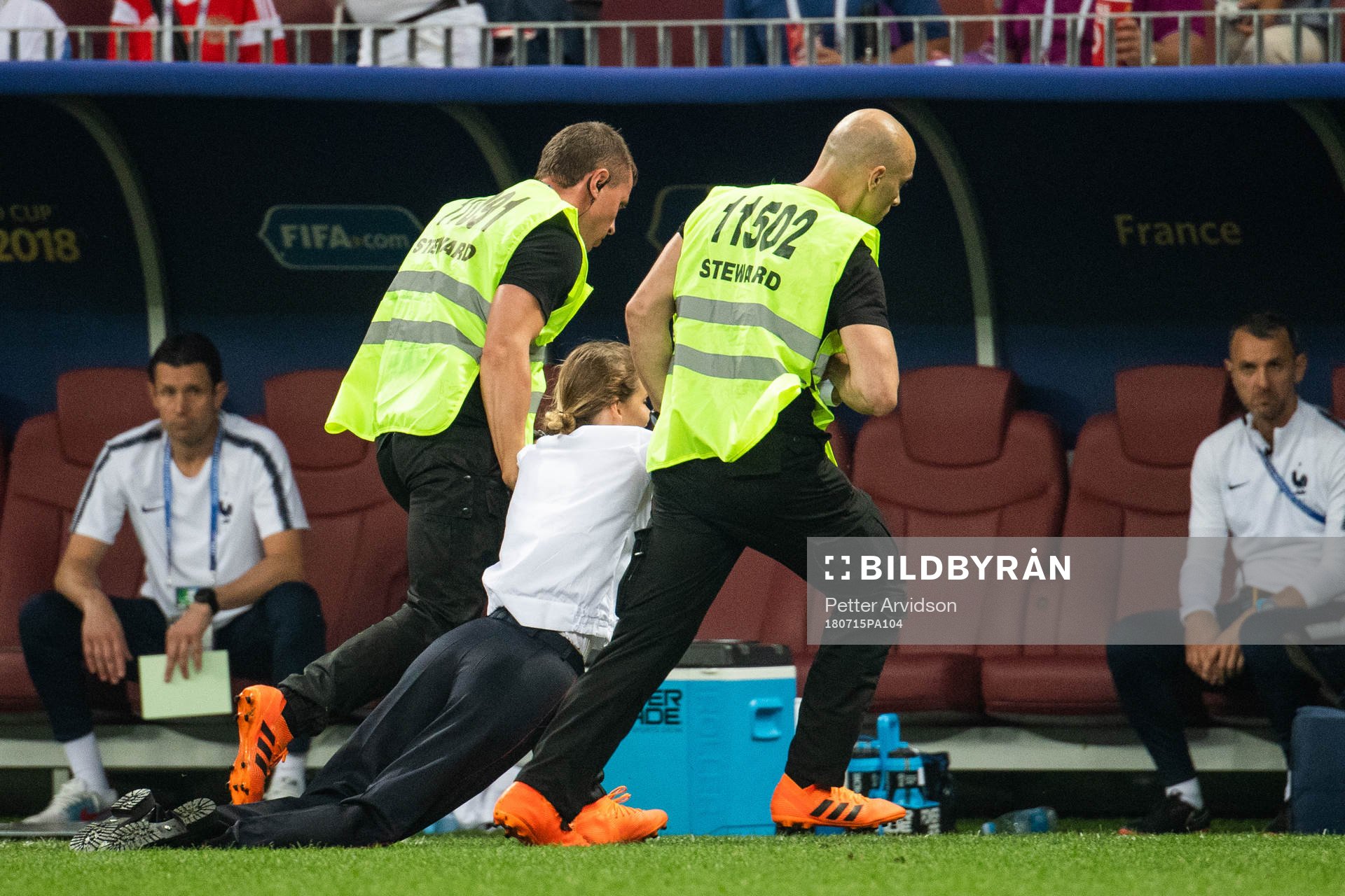 Stewards drag a pitch invader away
