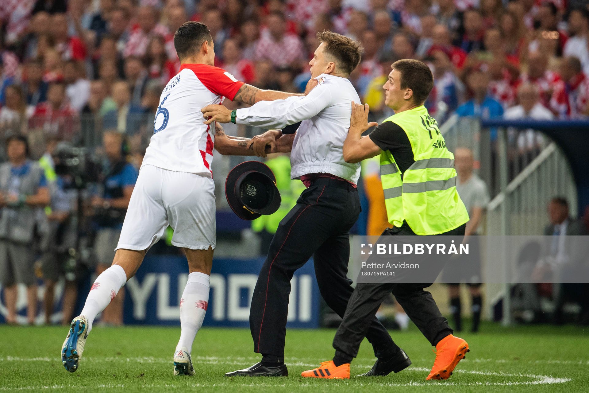 Dejan Lovren of Croatia and steward in a situation with a pitch invader during the FIFA World Cup final match between France and Croatia on July 15, 2018 in Moscow.