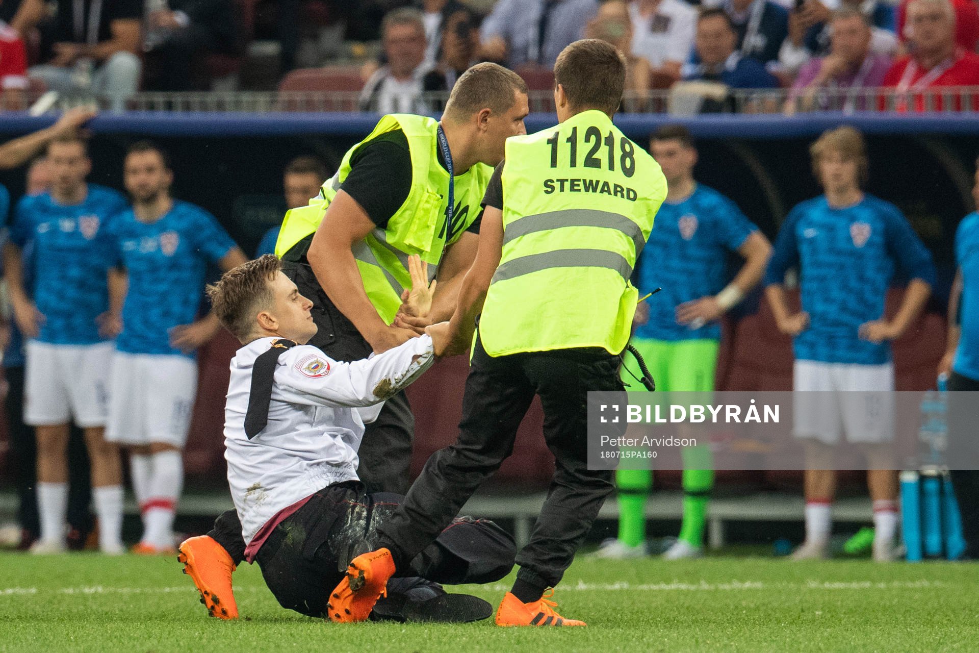 Stewards drag a pitch invader