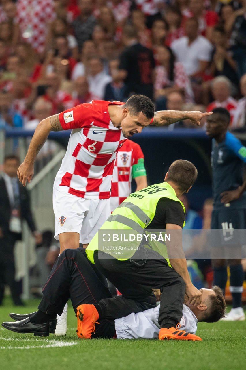 Dejan Lovren of Croatia reacts against a pitch invader who