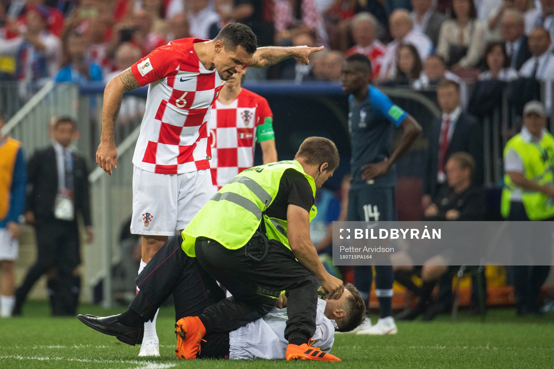 Dejan Lovren of Croatia reacts against a pitch invader who
