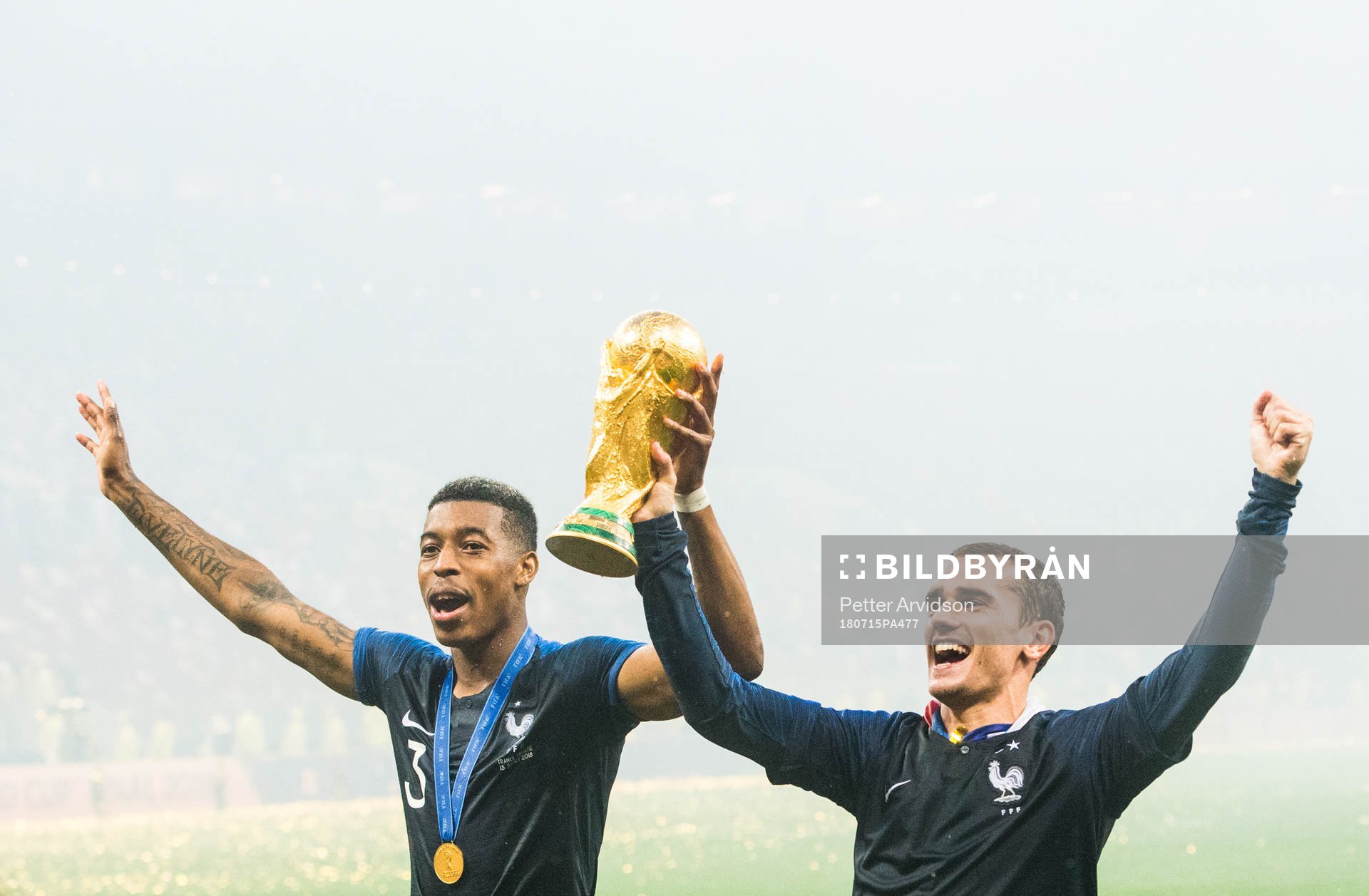 Presnel Kimpembe and Antoine Griezmann of France celebrate with the trophy after winning the FIFA World Cup final match between France and Croatia on July 15, 2018 in Moscow.