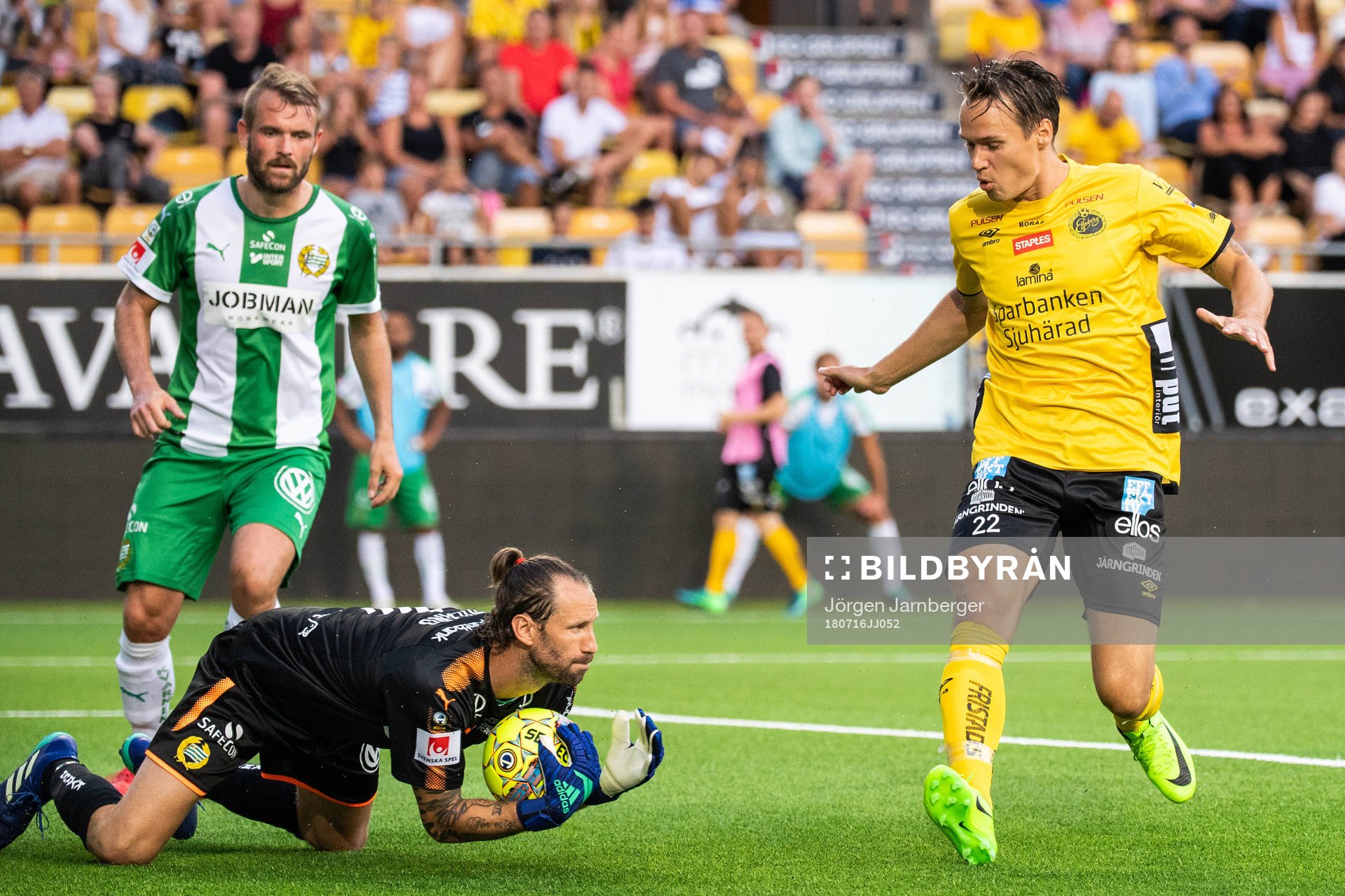 Hammarbys målvakt Johan Wiland tar bollen framför