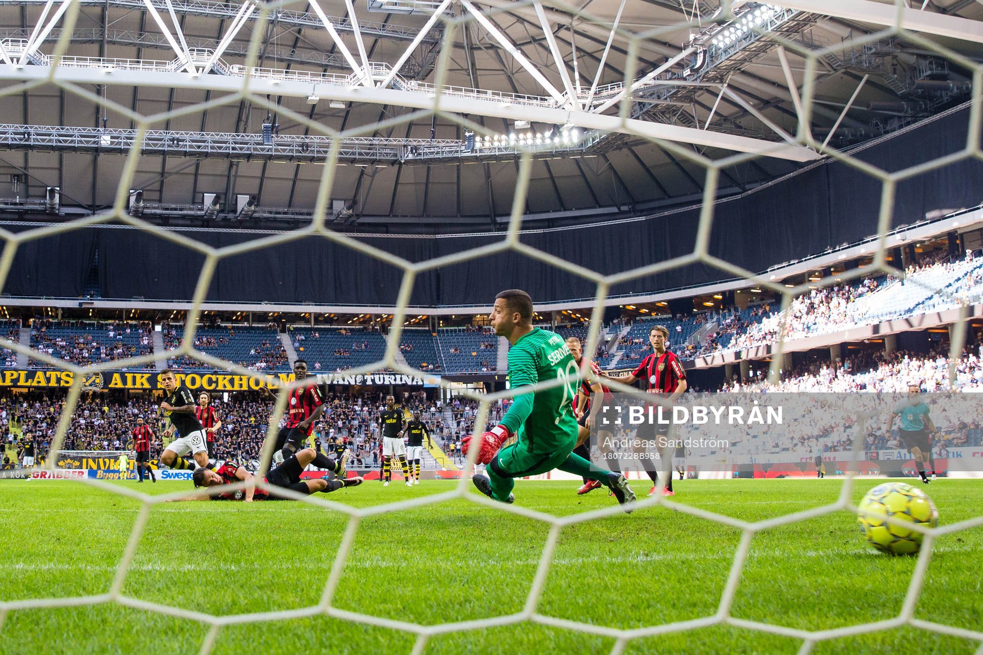 AIK:s Nicolas Stefanelli gör 2-1 bakom Brommapojkarnas målvakt Nikola Petric under fotbollsmatchen i Allsvenskan mellan AIK och Brommapojkarna den 22 juli 2018 i Stockholm.
