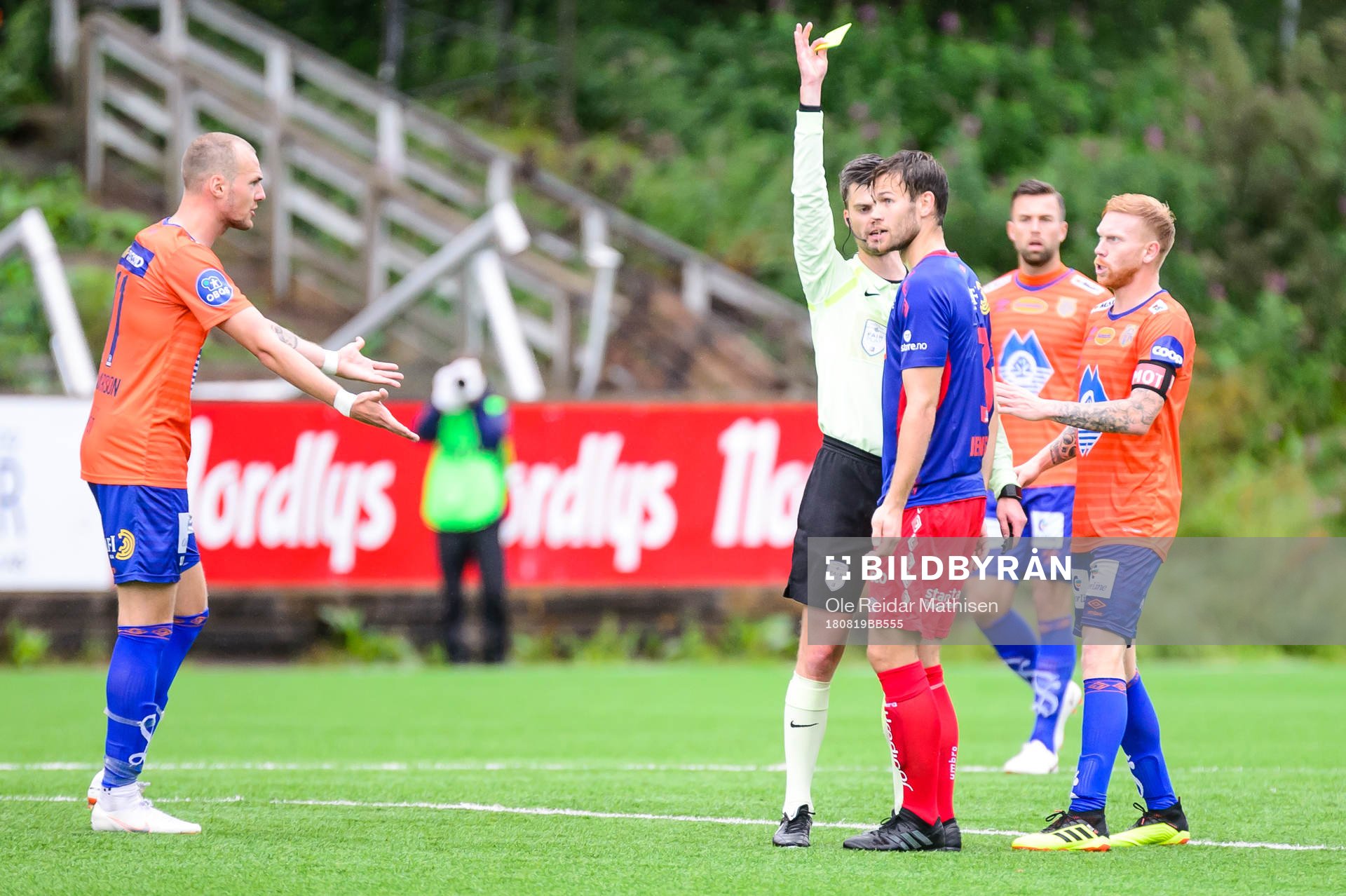 Mathias Dahl Abelsen of Tromsdalen receives a yellow card
