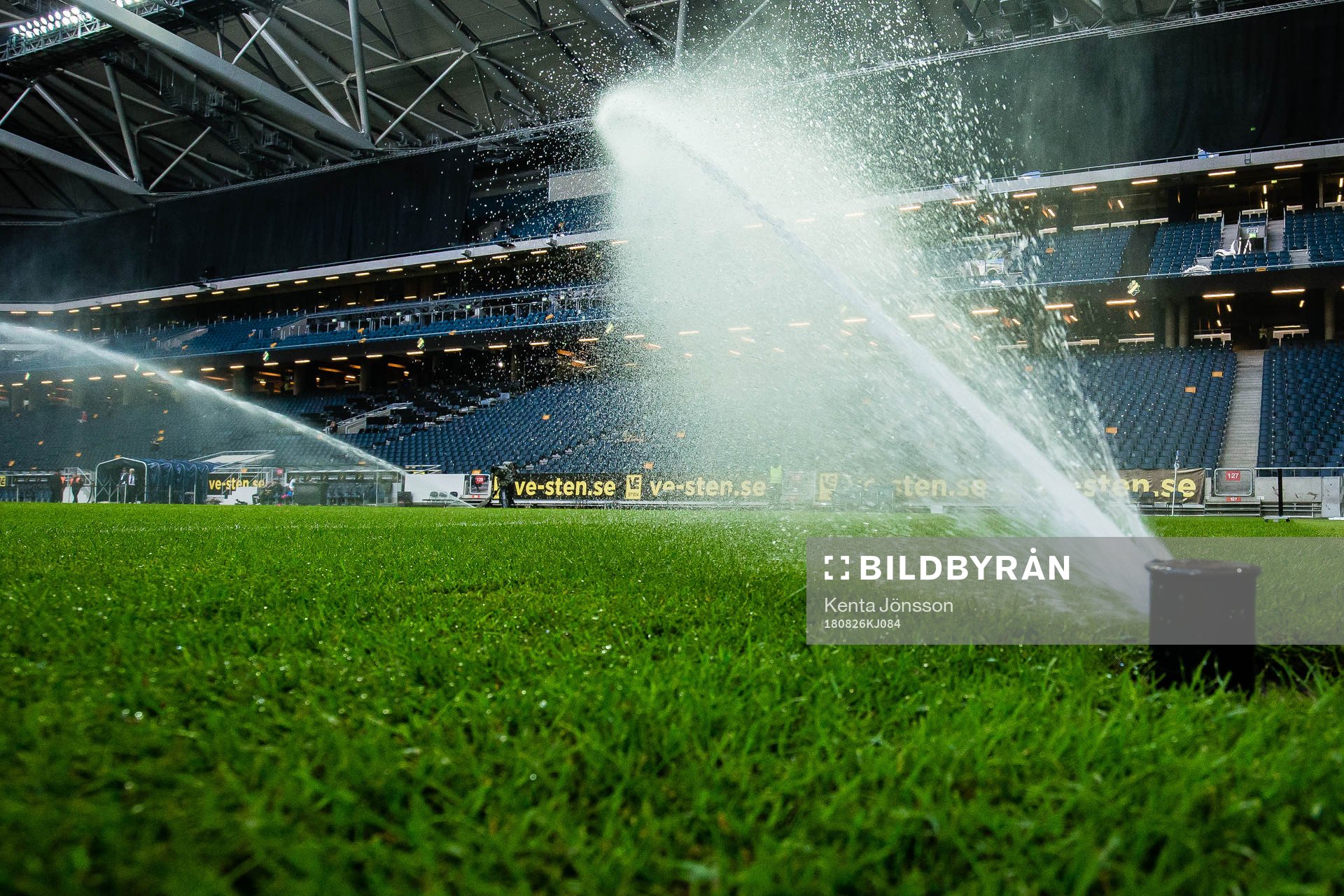 En vattenspridare på naturgräset på Friends Arena innan