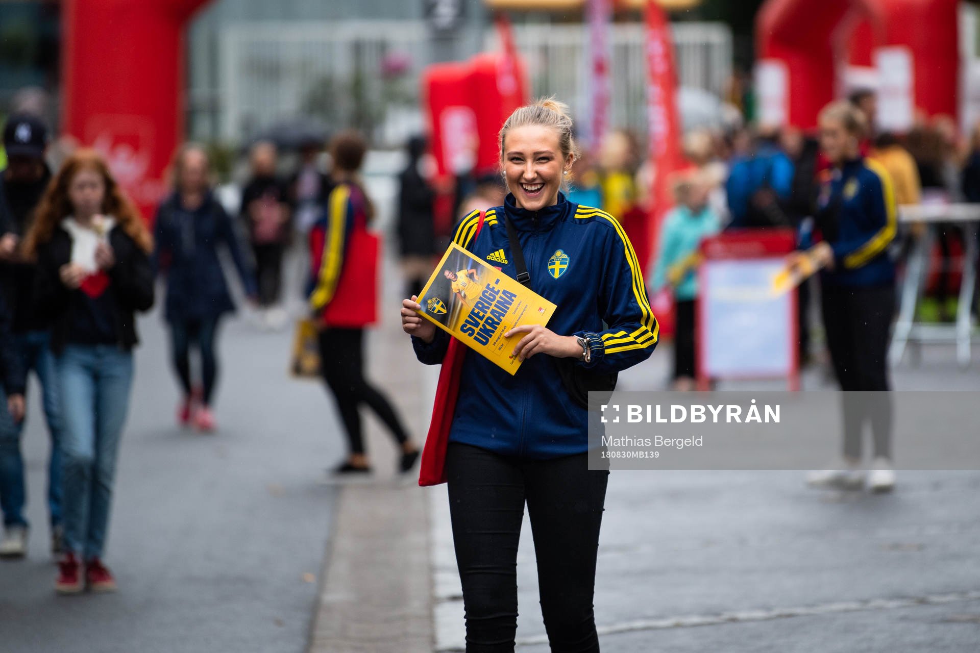 En tjej säljer matchblad i fanzone
