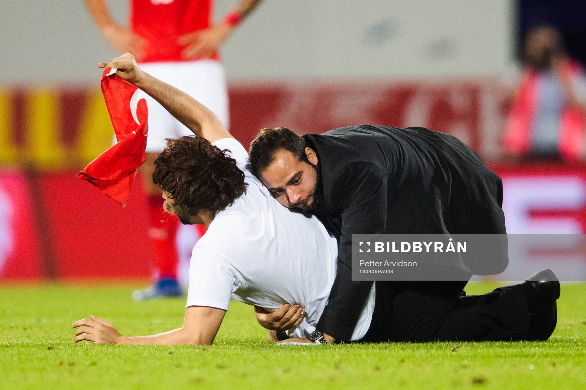 A pitch invader is wrestled by security