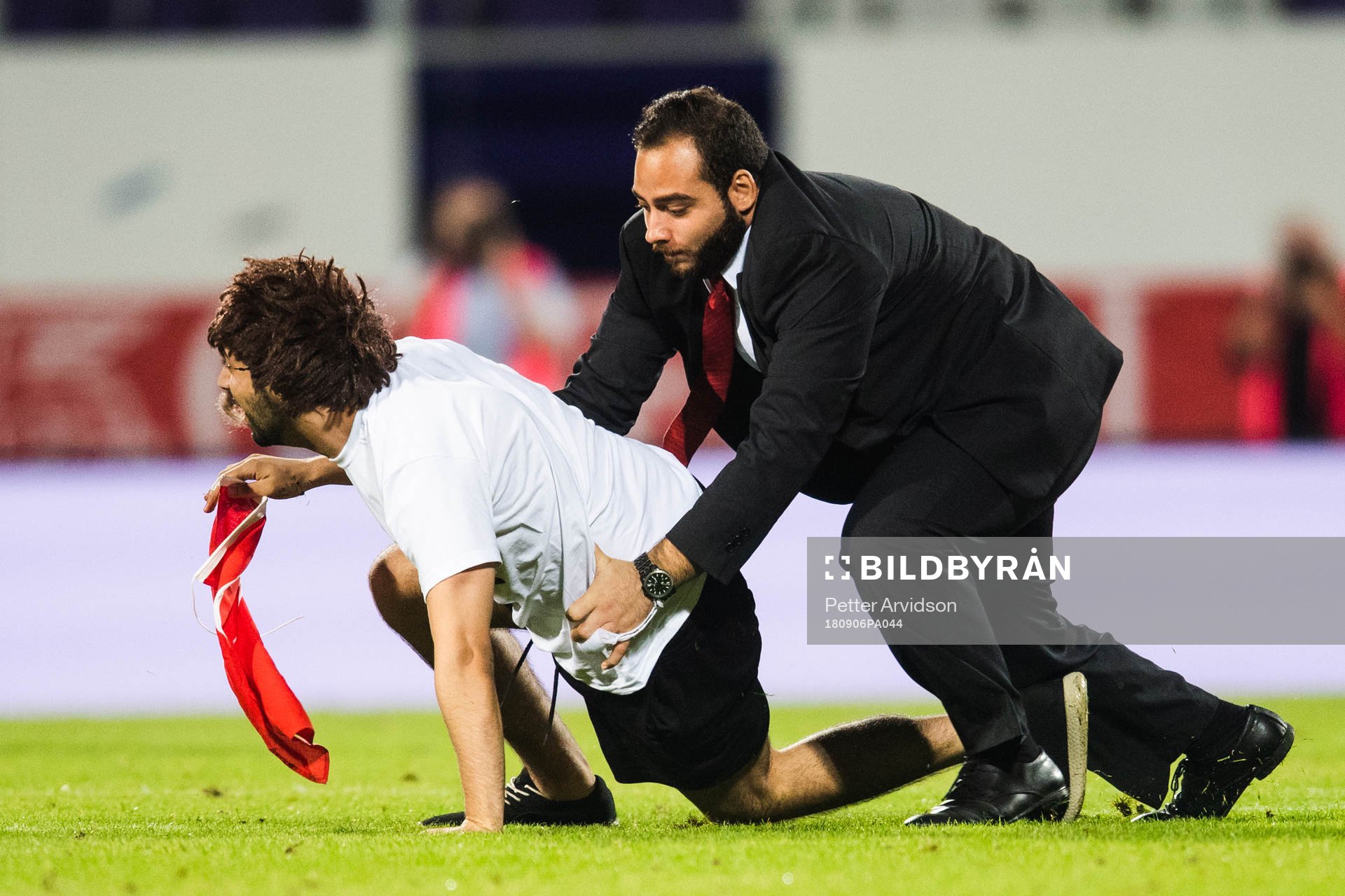 A pitch invader is wrestled by security