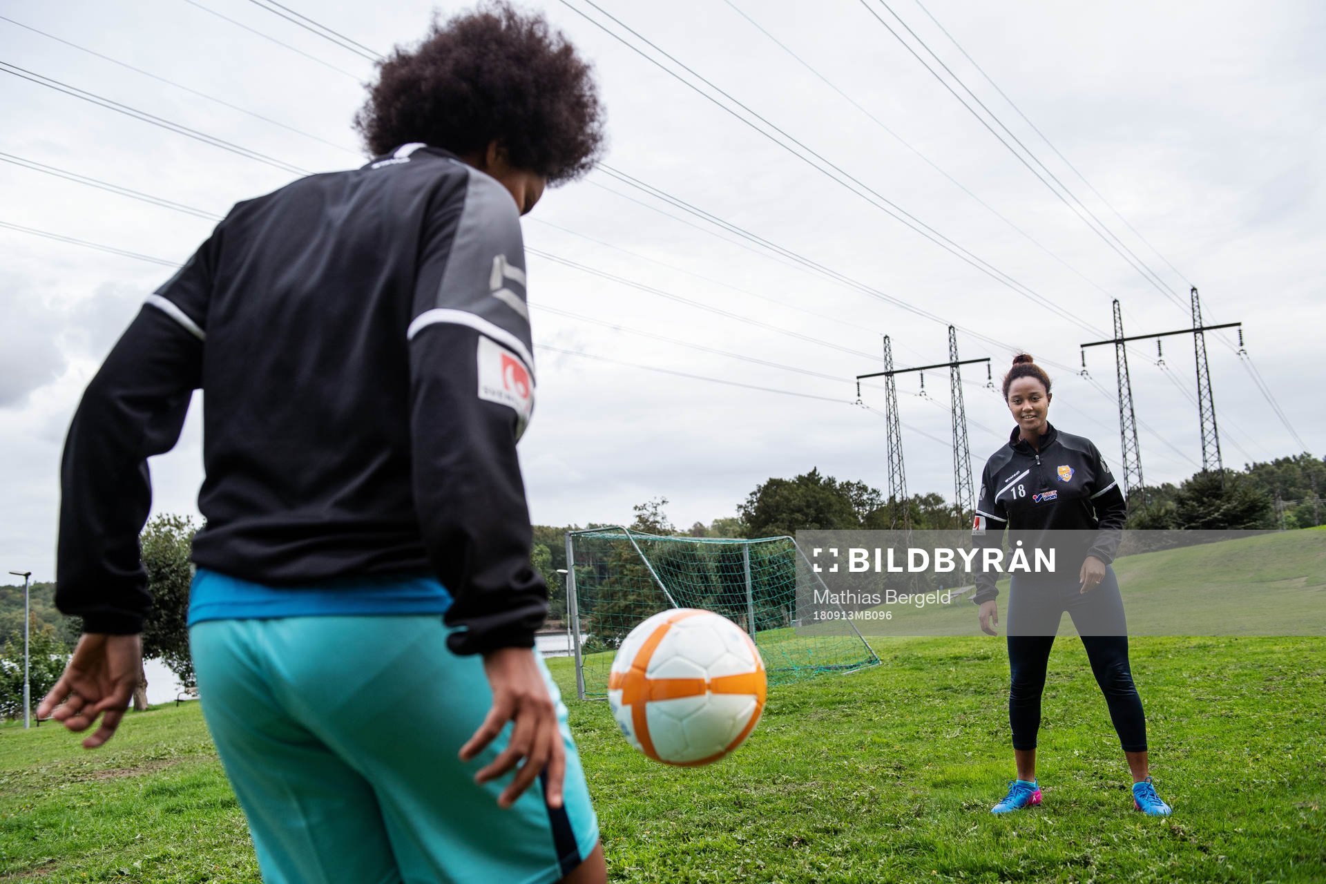 Tutu Belay och Loza Abera spelar fotboll på en gräsplätt