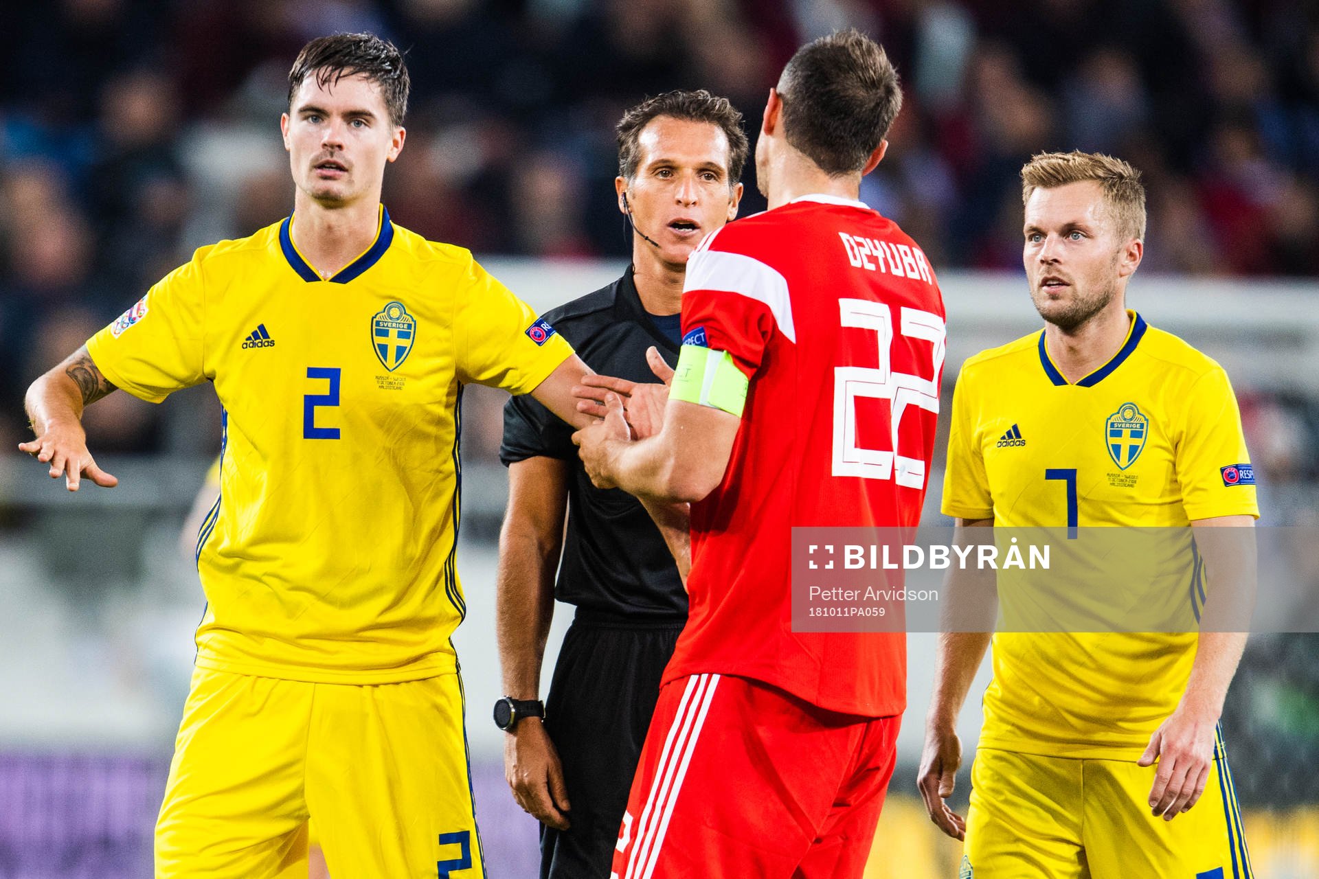 Mikael Lustig and Sebastian Larsson of Sweden with referee