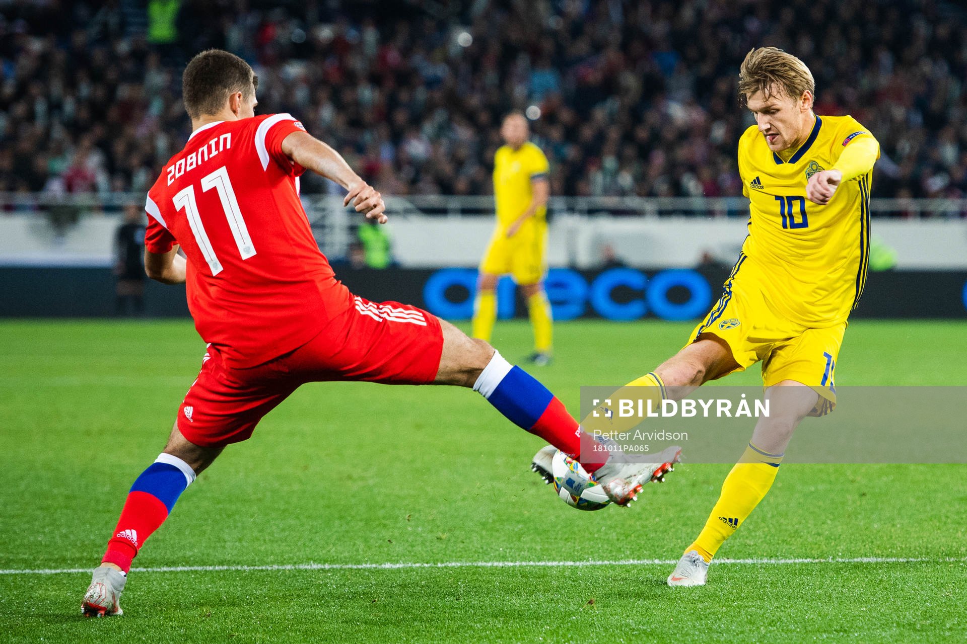 Roman Zobnin of Russia defends against Emil Forsberg of