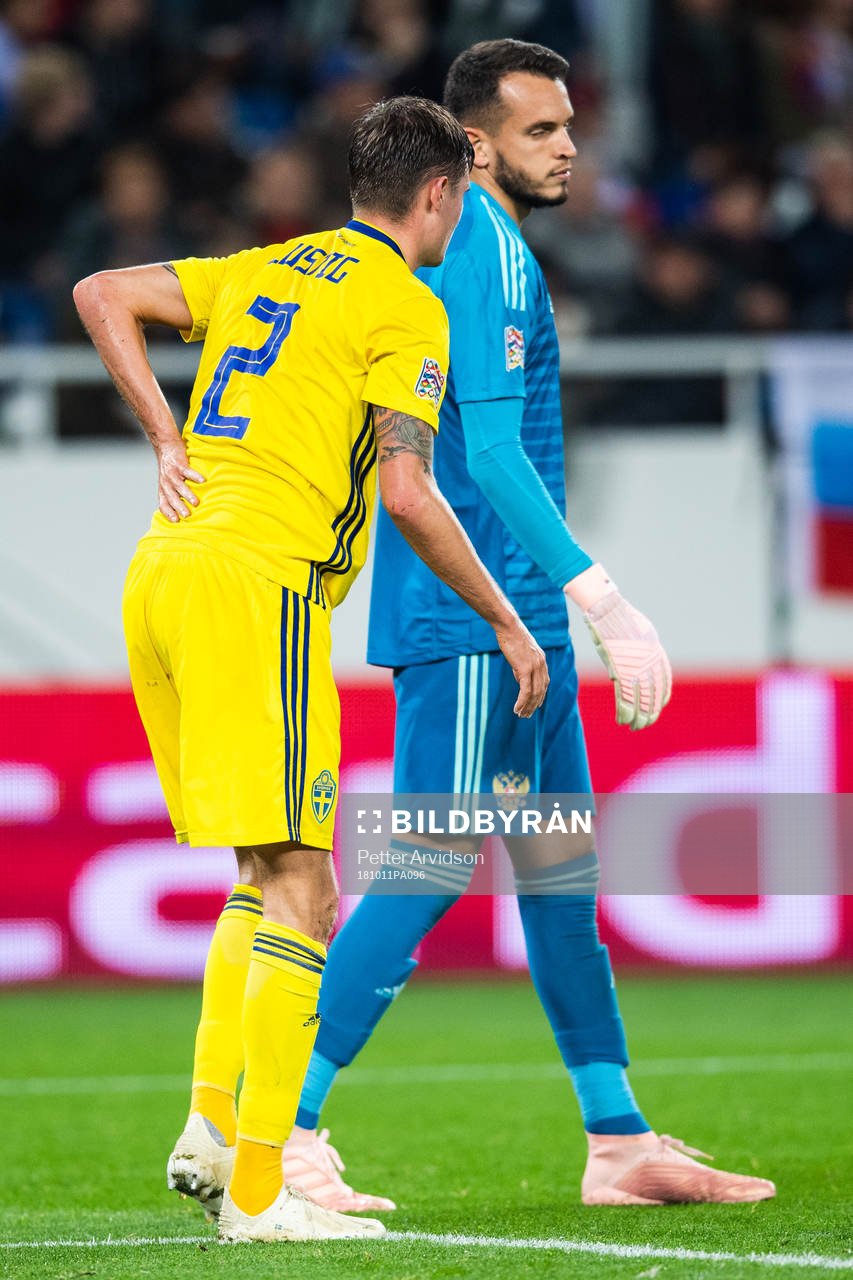 Mikael Lustig of Sweden reaches for his back
