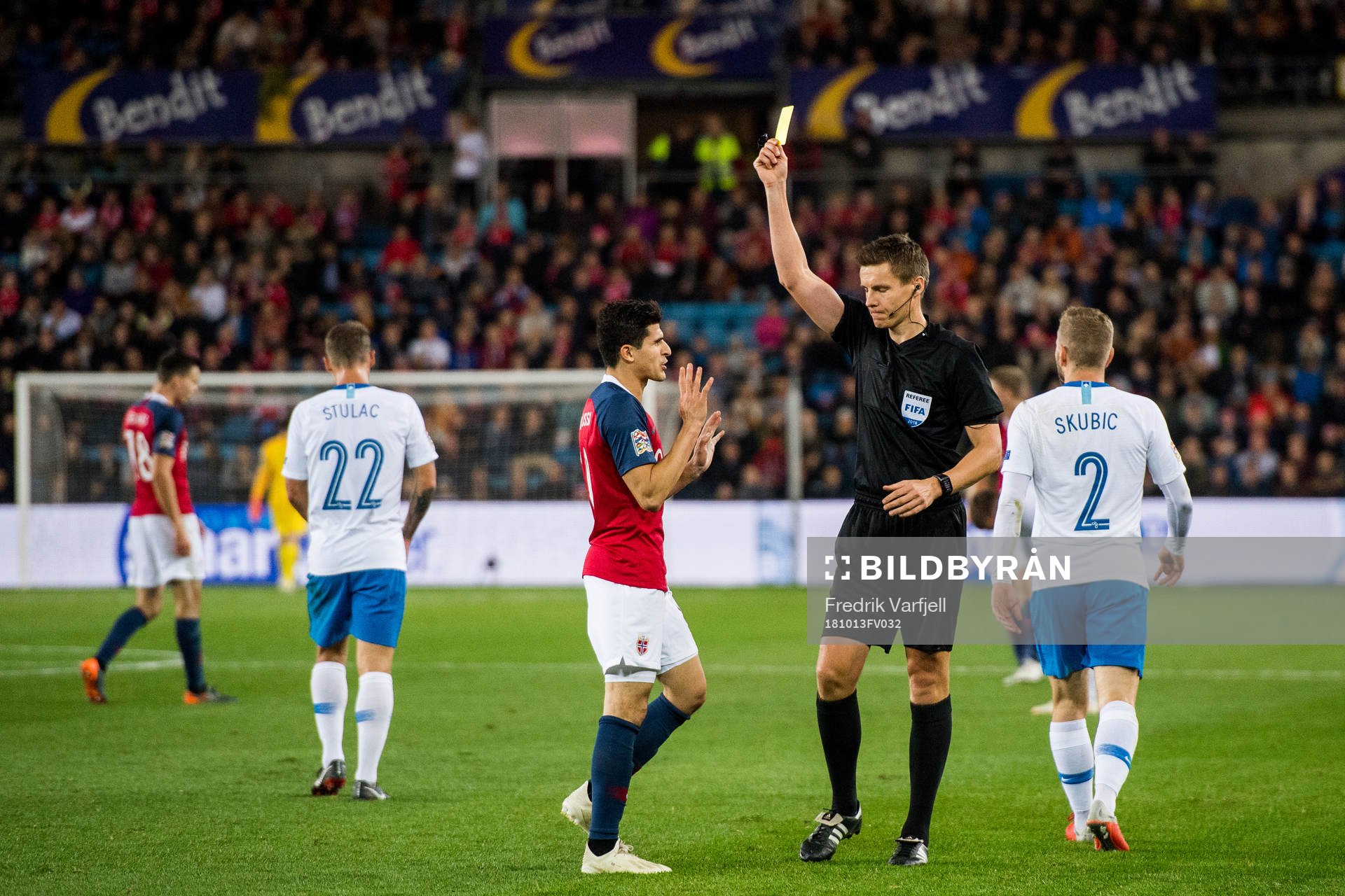 Tarik Elyounoussi of Norway is shown a yellow card by