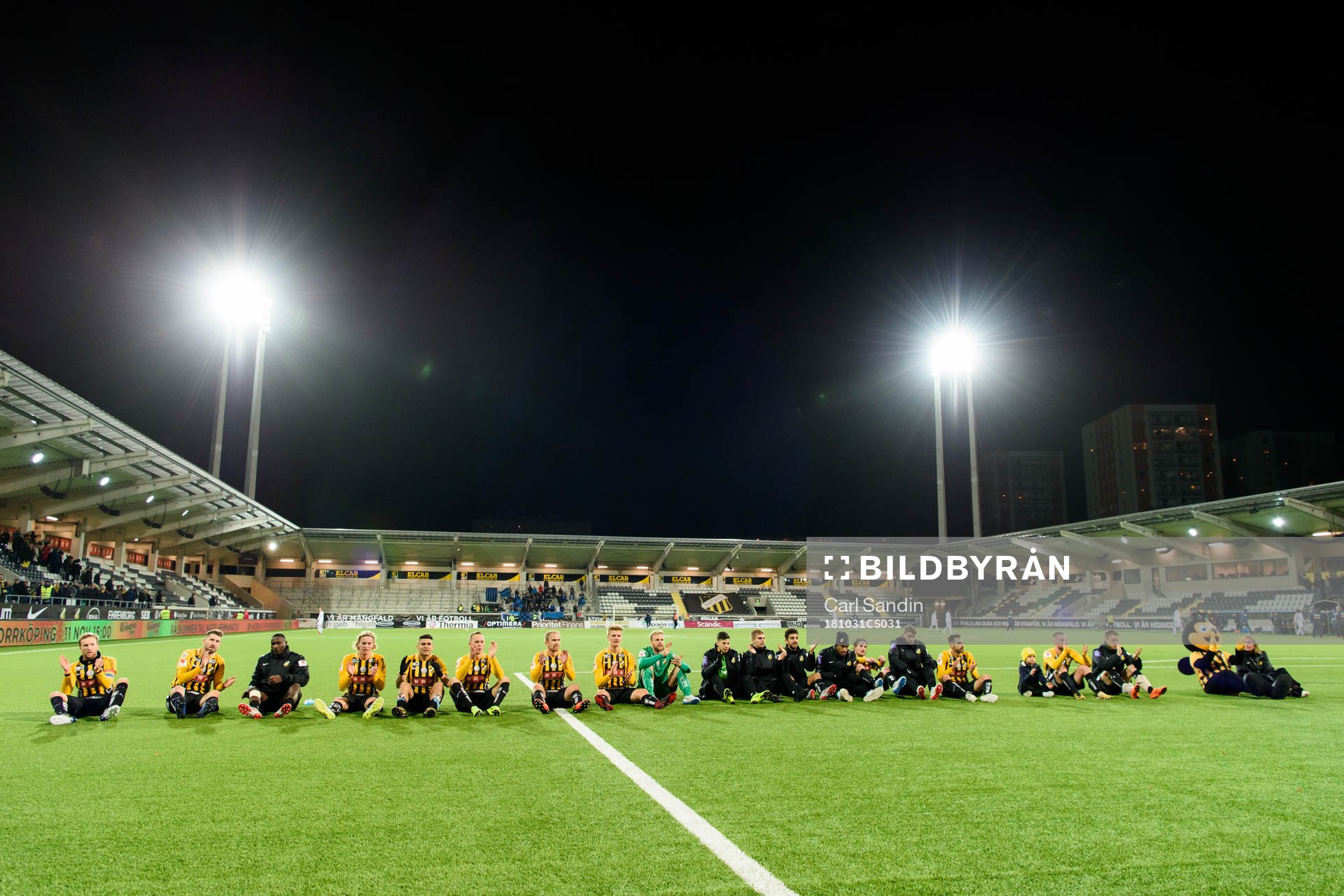 Häckens spelare sitter på planen framför supportrarna