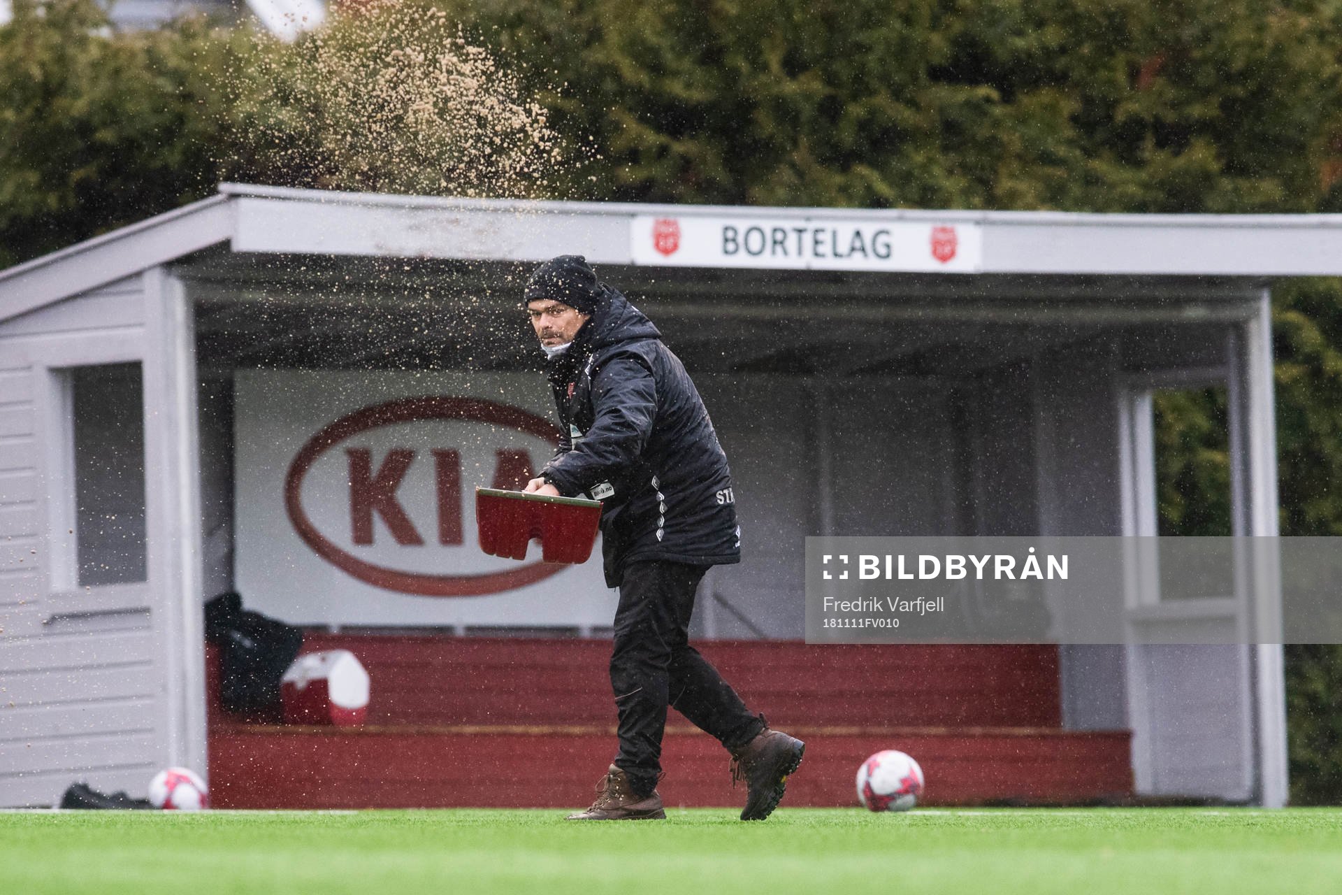 A janitor removing water from the pitch