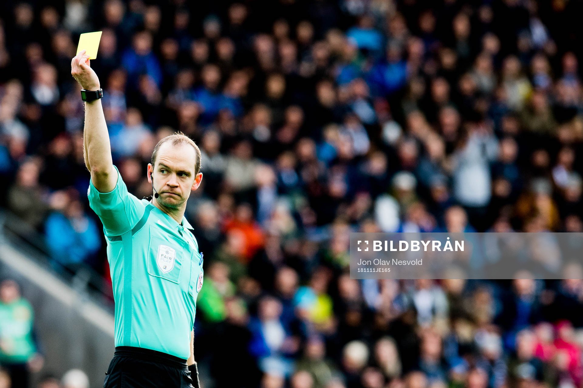 Christian Moen, referee, shows a yellow card