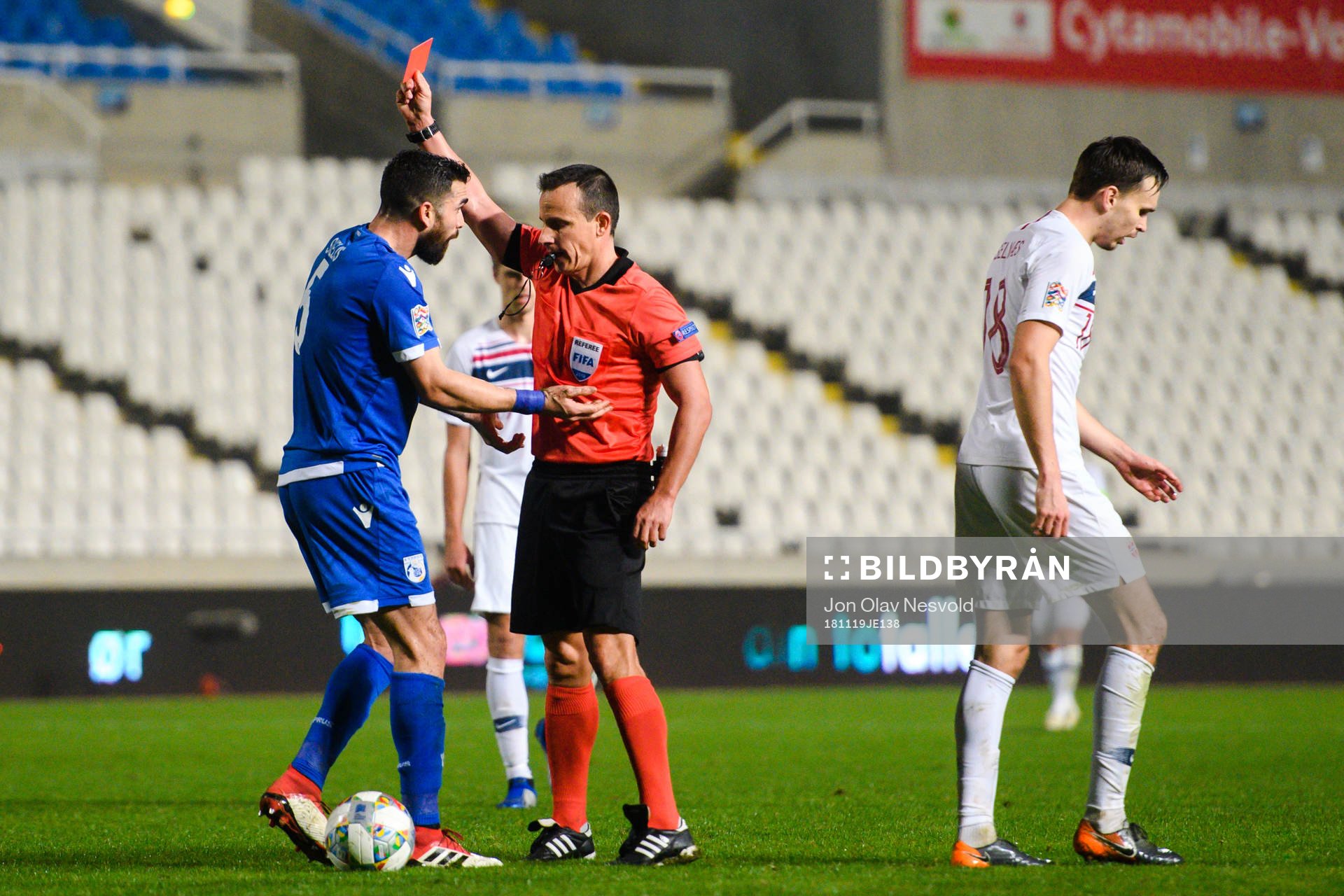 Valentinos Sielis of Cyprus receives a red card from