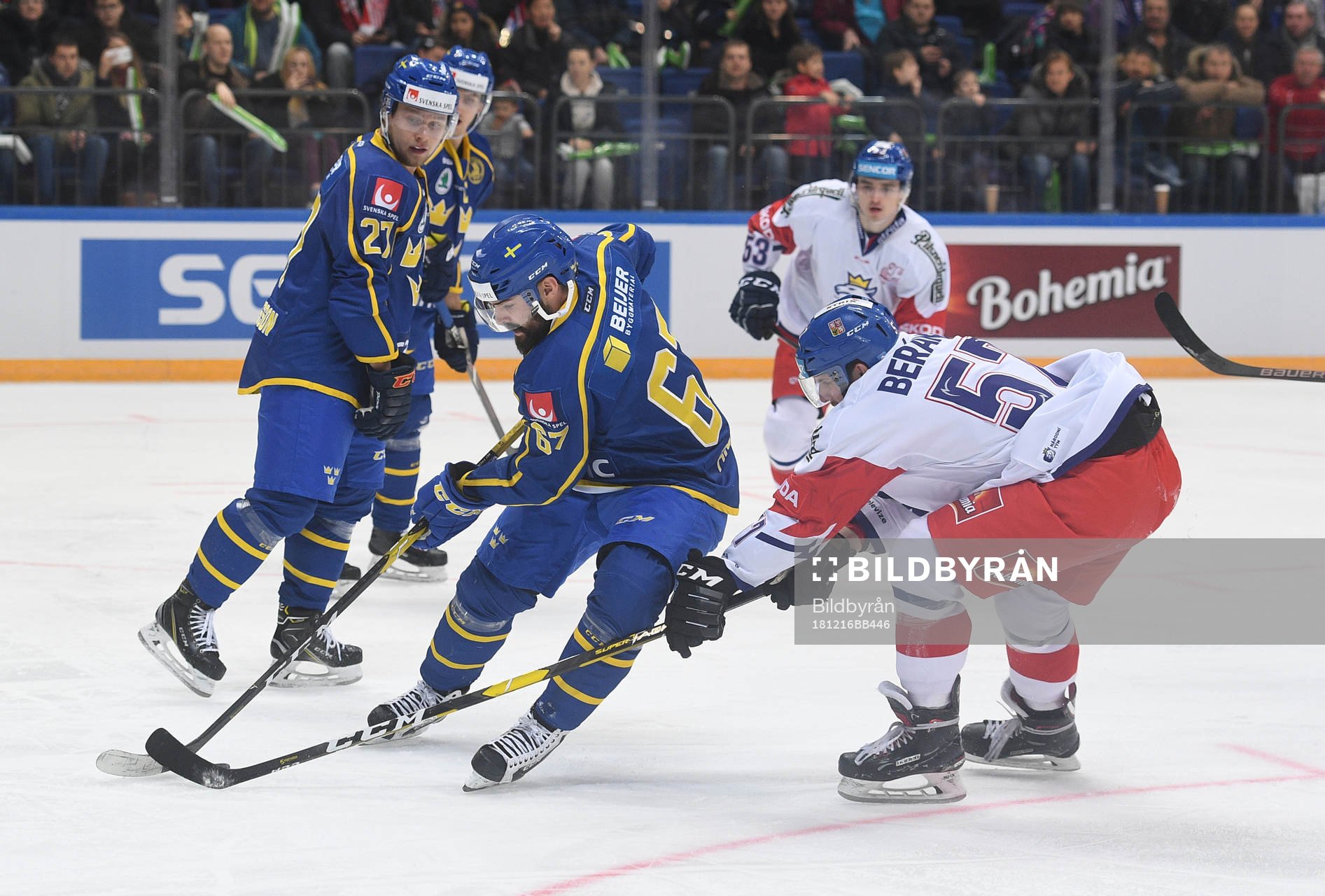 Sweden's Linus Froberg, centre, struggles for a puck with