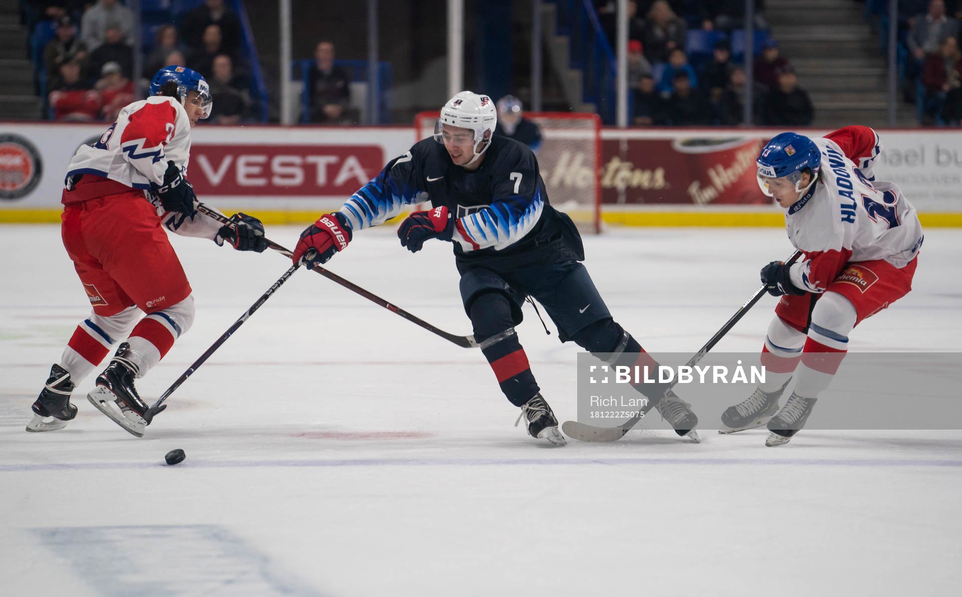 Quinn Hughes #7 of the United States gets past Jan Hladonik