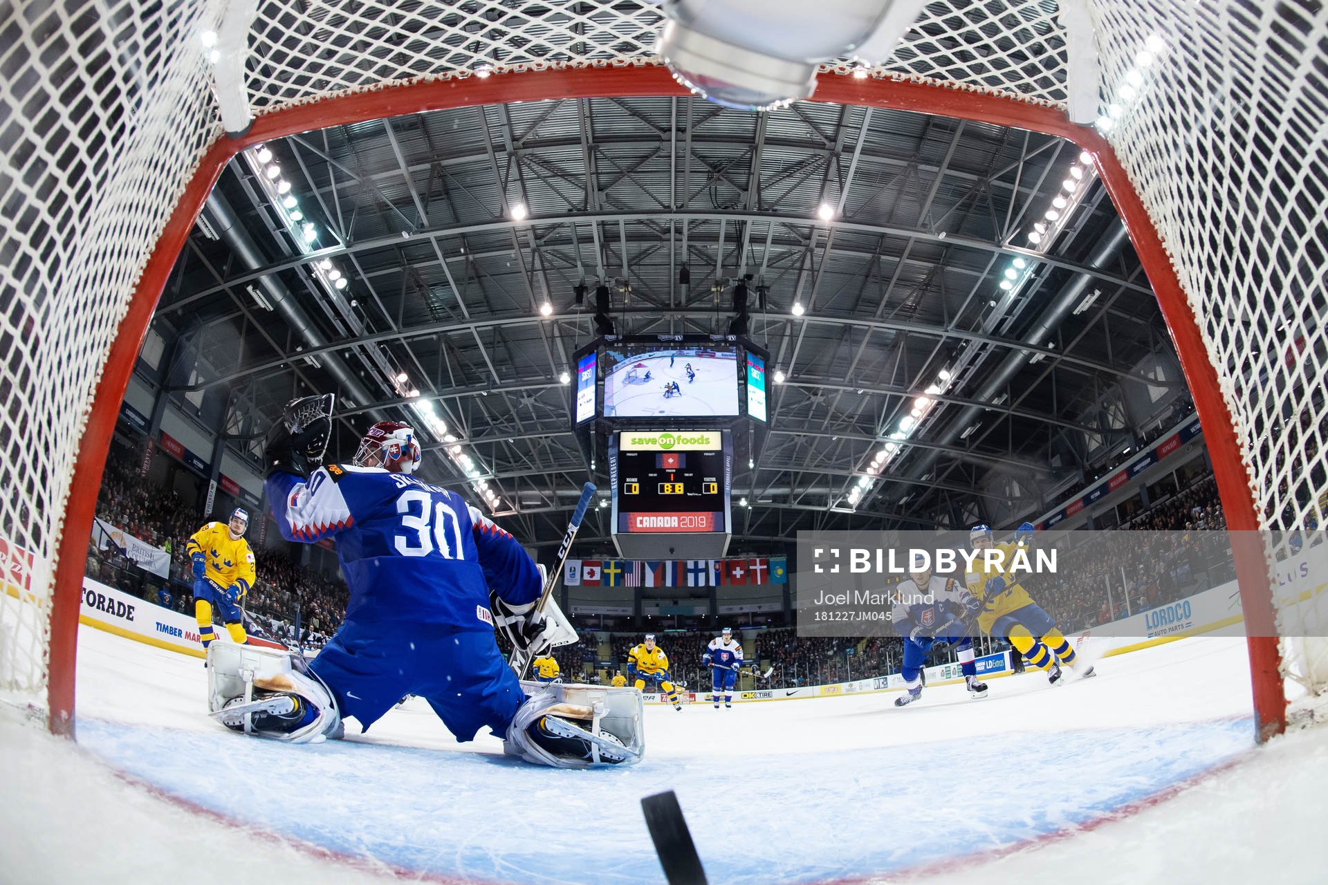 Lucas Elvenes of Sweden scores 0-1 behind goaltender Juraj