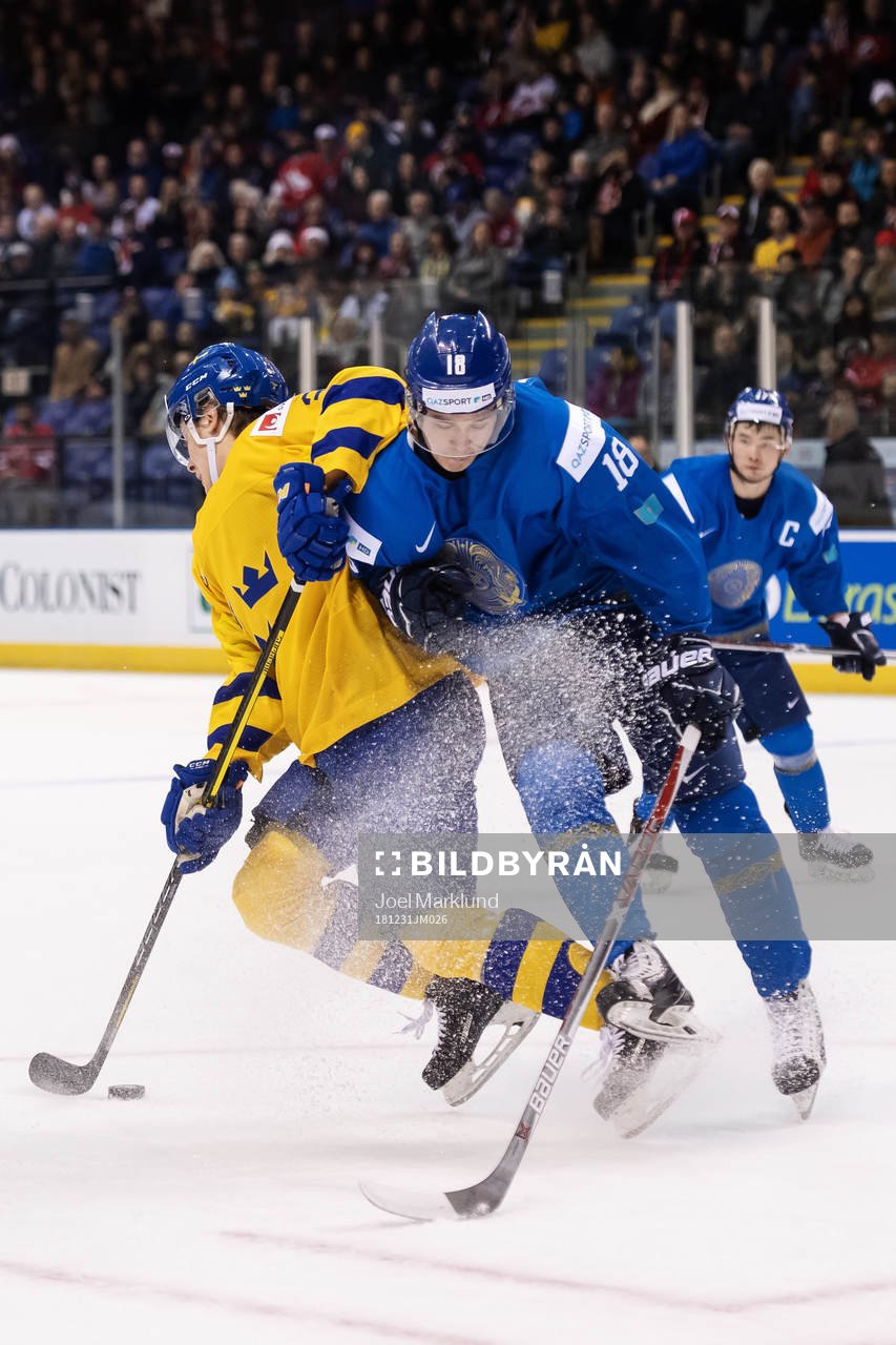 Adam Boqvist of Sweden is being tackled by Batyrlan Muratov