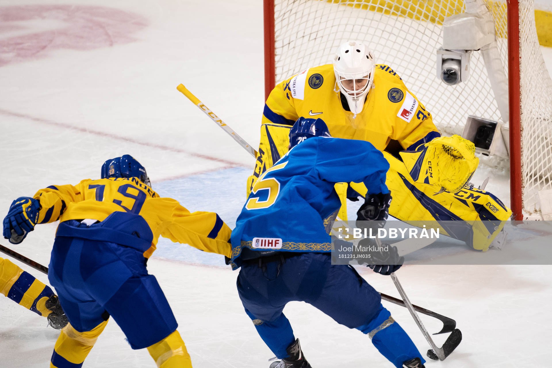 Dmitri Mitenkovk of Kazakhstan attacks against goaltender