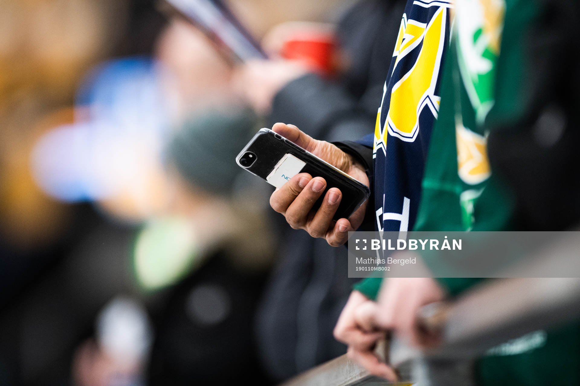 En HV71-supporter tittar i mobilen