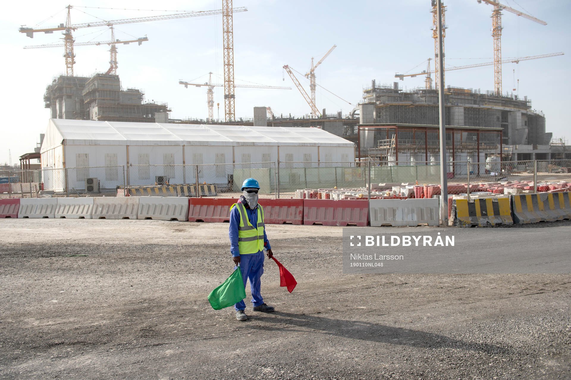 A worker is seen outside the construction of the Lusail