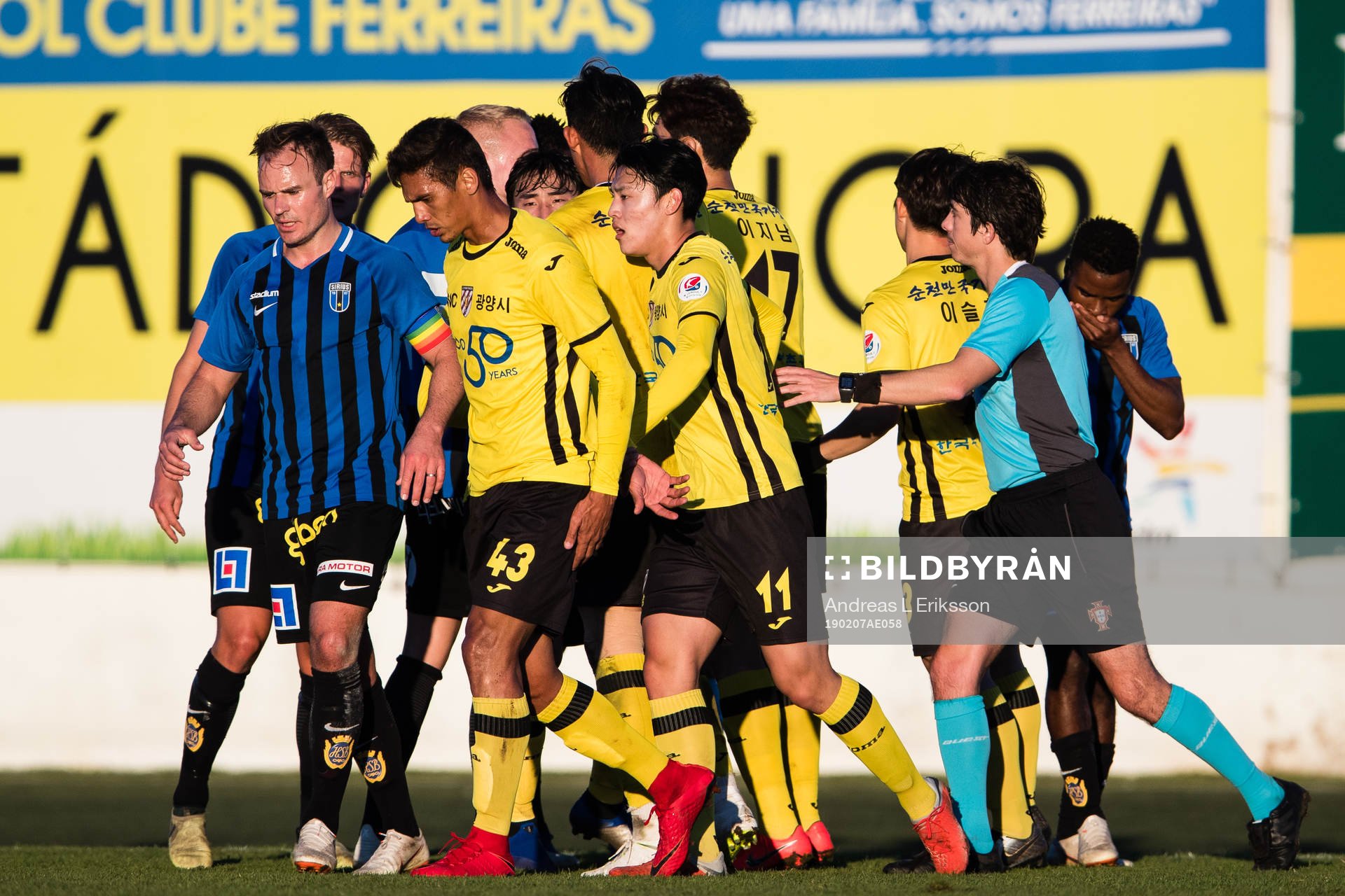 Sirius Niklas Busch Thor, Jeonnam Dragons Bruno Nunes och Chu Jungho med fler motas bort av domare José Salema under en träningsmatch i fotboll mellan Sirius och Jeonnam Dragons den 7 februari 2019 i Ferreiras.