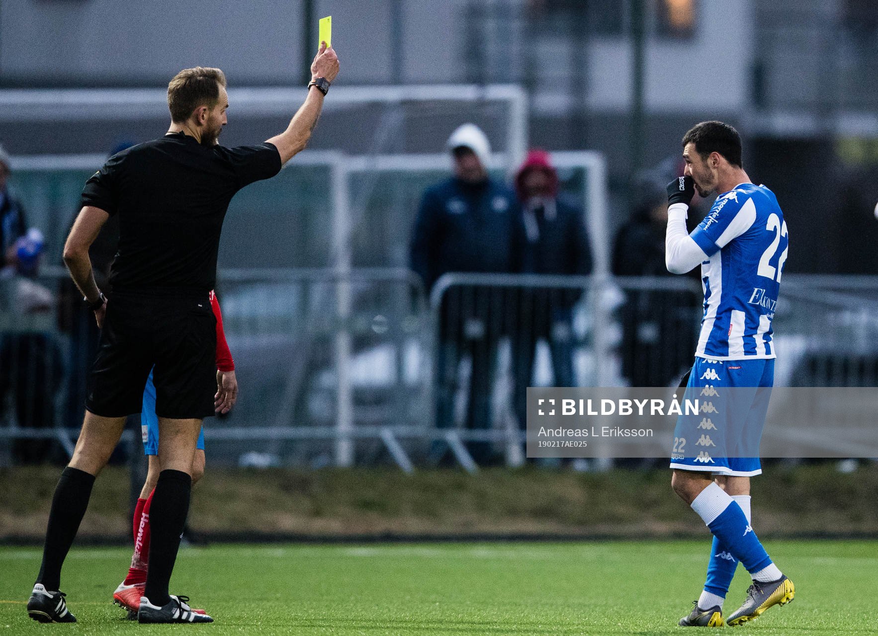 Domare Andreas Johansson delar ut ett gult kort till IFK