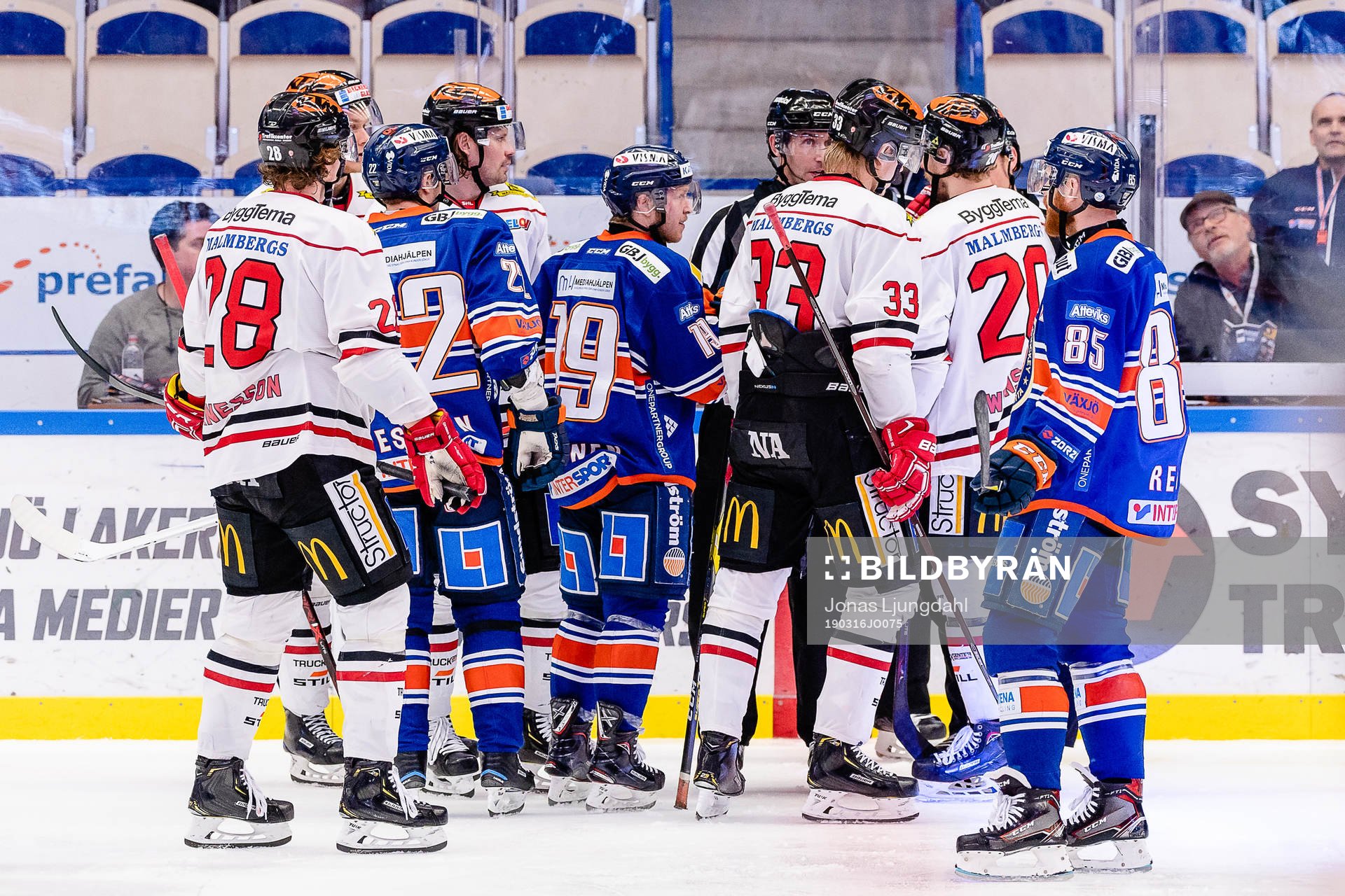 Spelare från båda lagen diskuterar med domarna