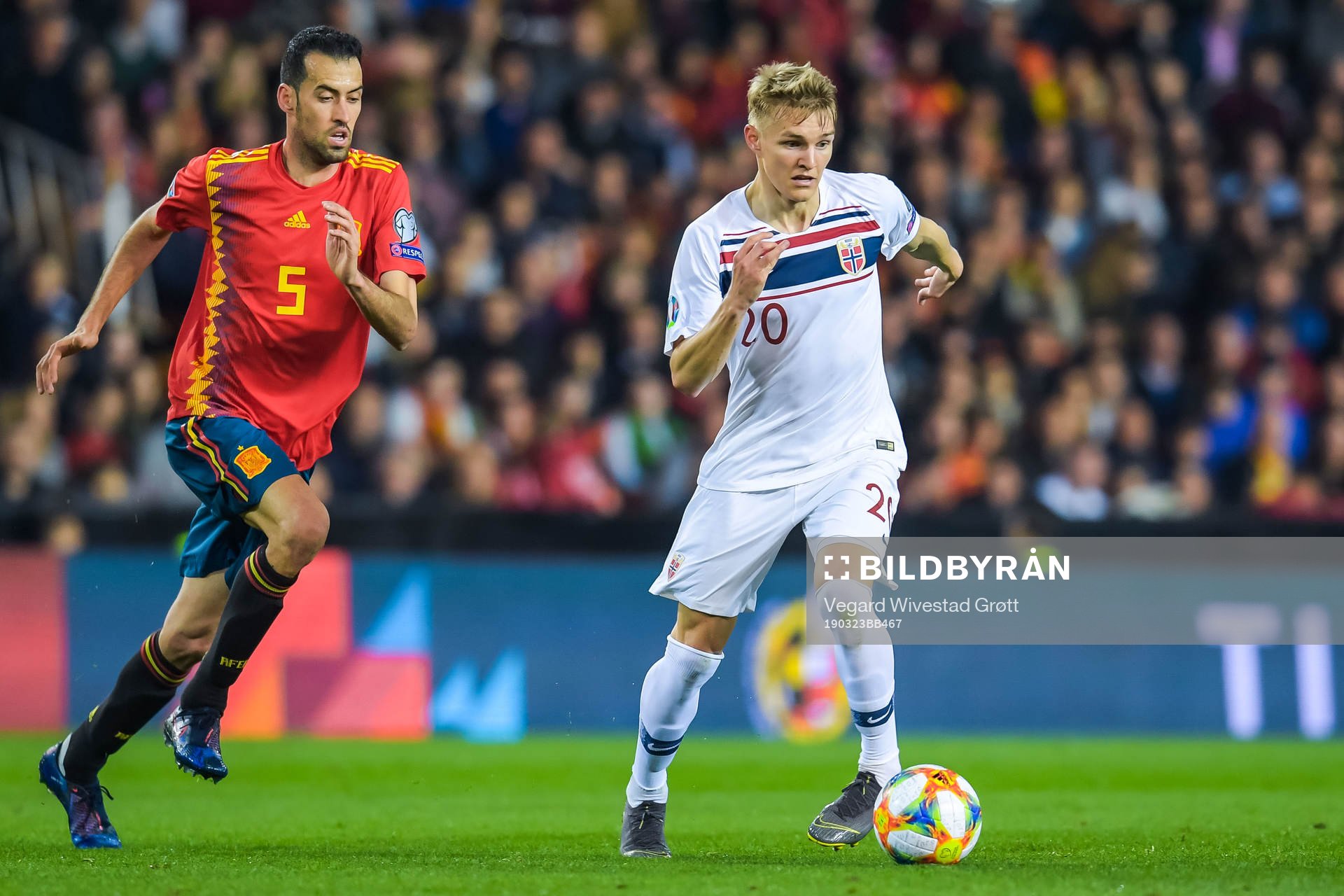 Sergio Busquets of Spain and Martin Ødegaard of Norway