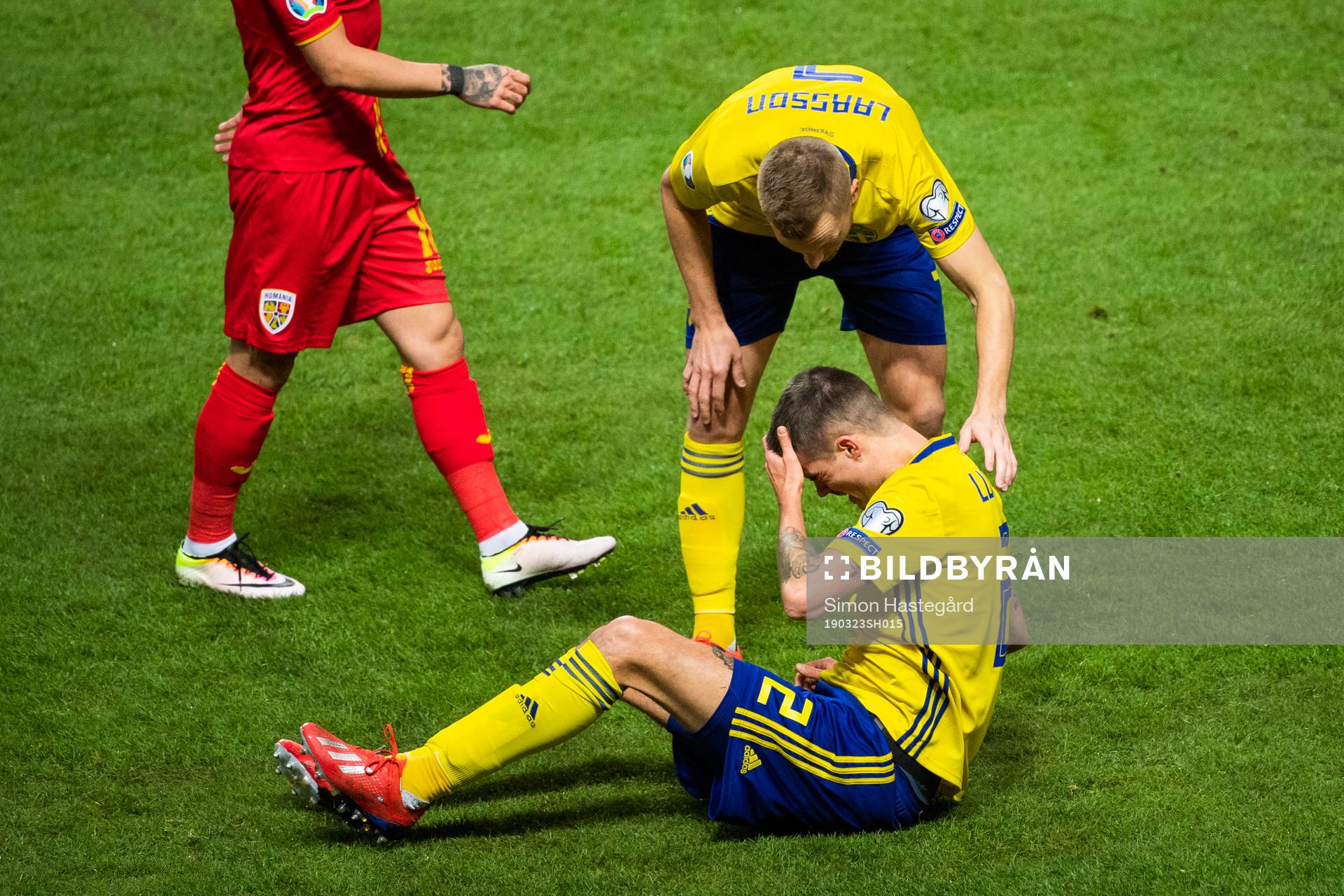 Sebastian Larsson tends to Mikael Lustig of Sweden
