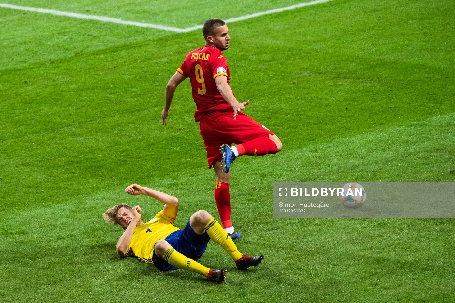 Filip Helander of Sweden falls in a duel with George Puscas