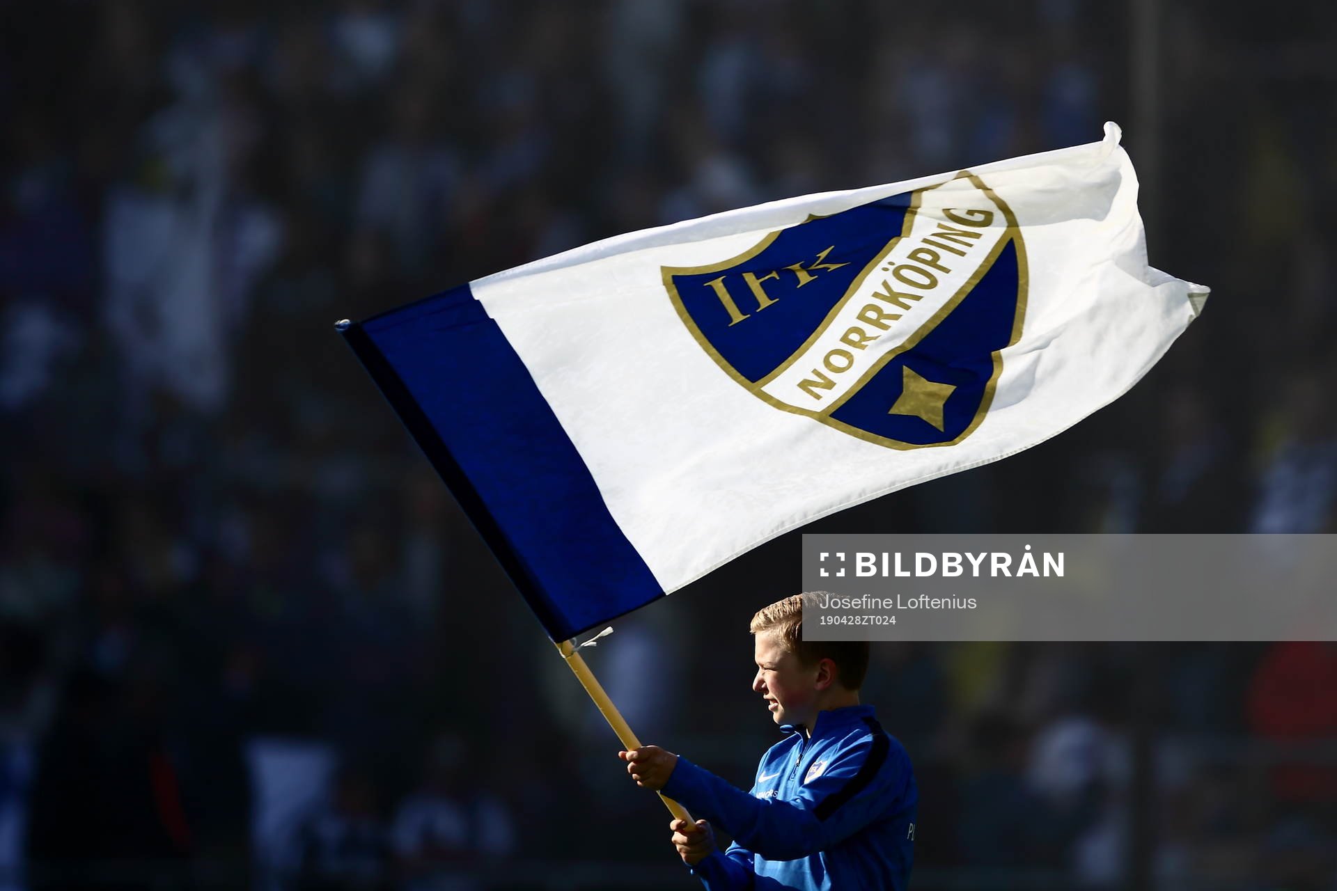 Pojke med IFK Norrköpingflagga innan  fotbollsmatchen i