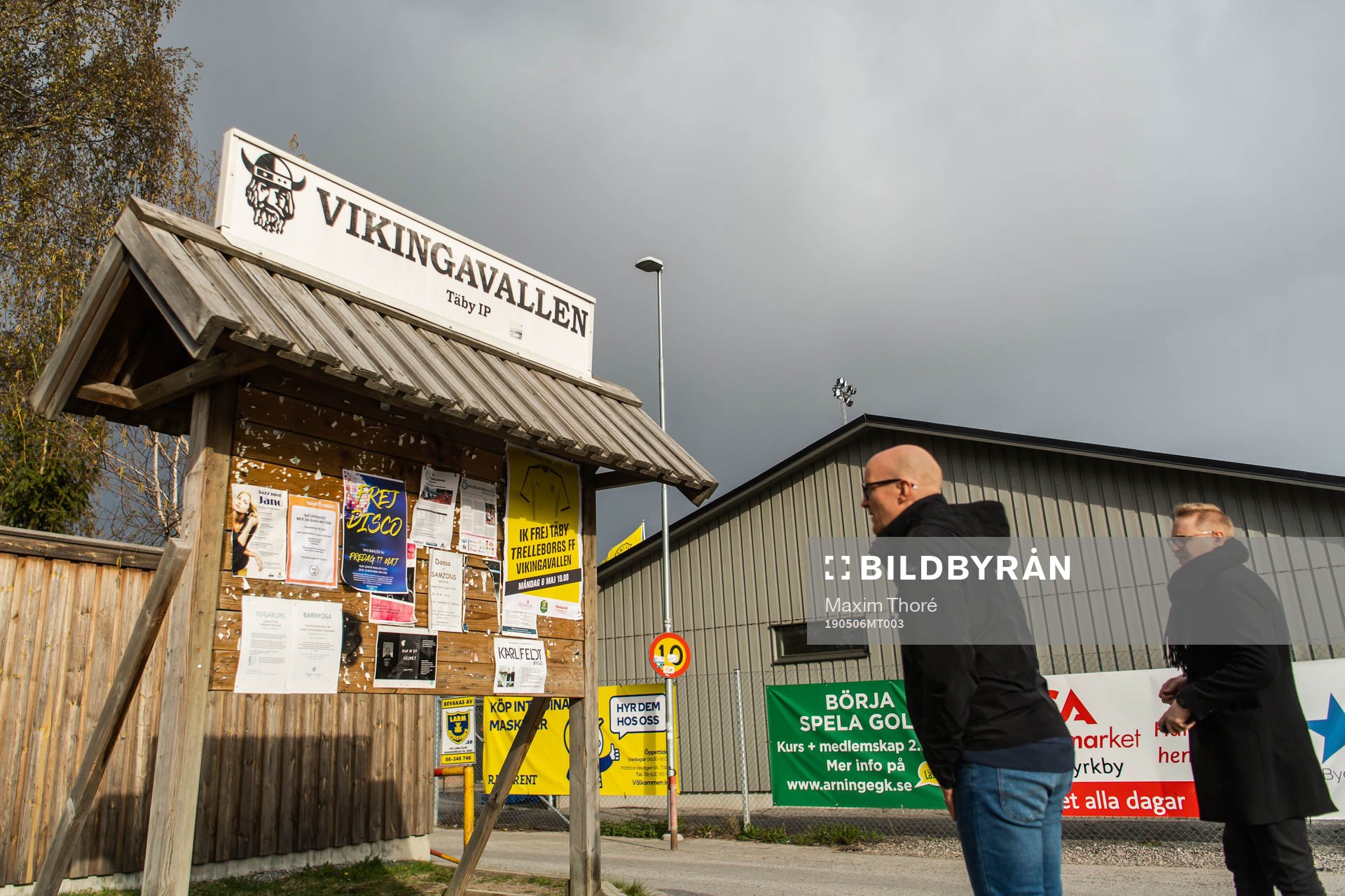 Två personer kollar in en anslagstavla över Vikingavallen